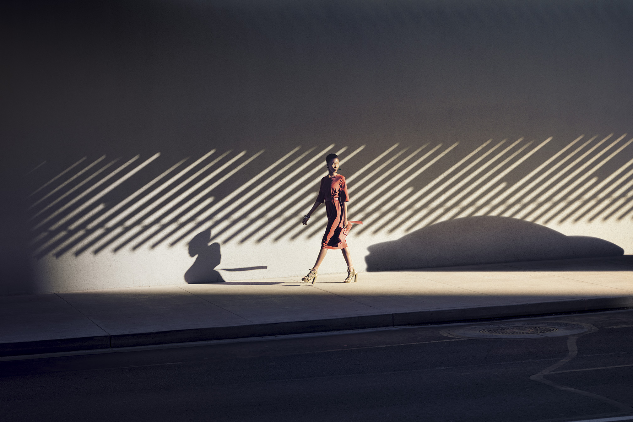 Women walking along the sidewalk next to shadow of Taycan