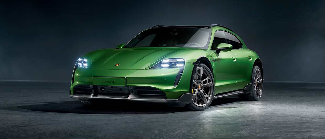 Green Porsche Taycan Sports Turismo against dark grey background