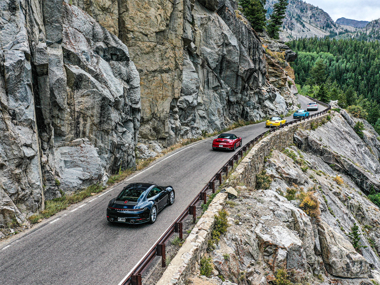 Porsche cars driving along a canyon road