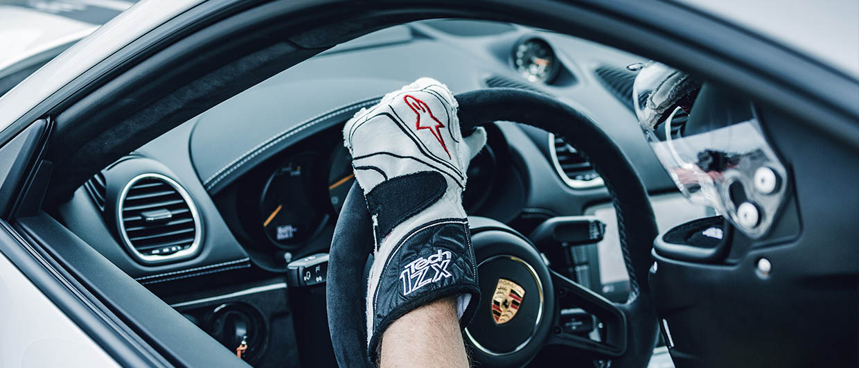 Left hand on Porsche steering wheel