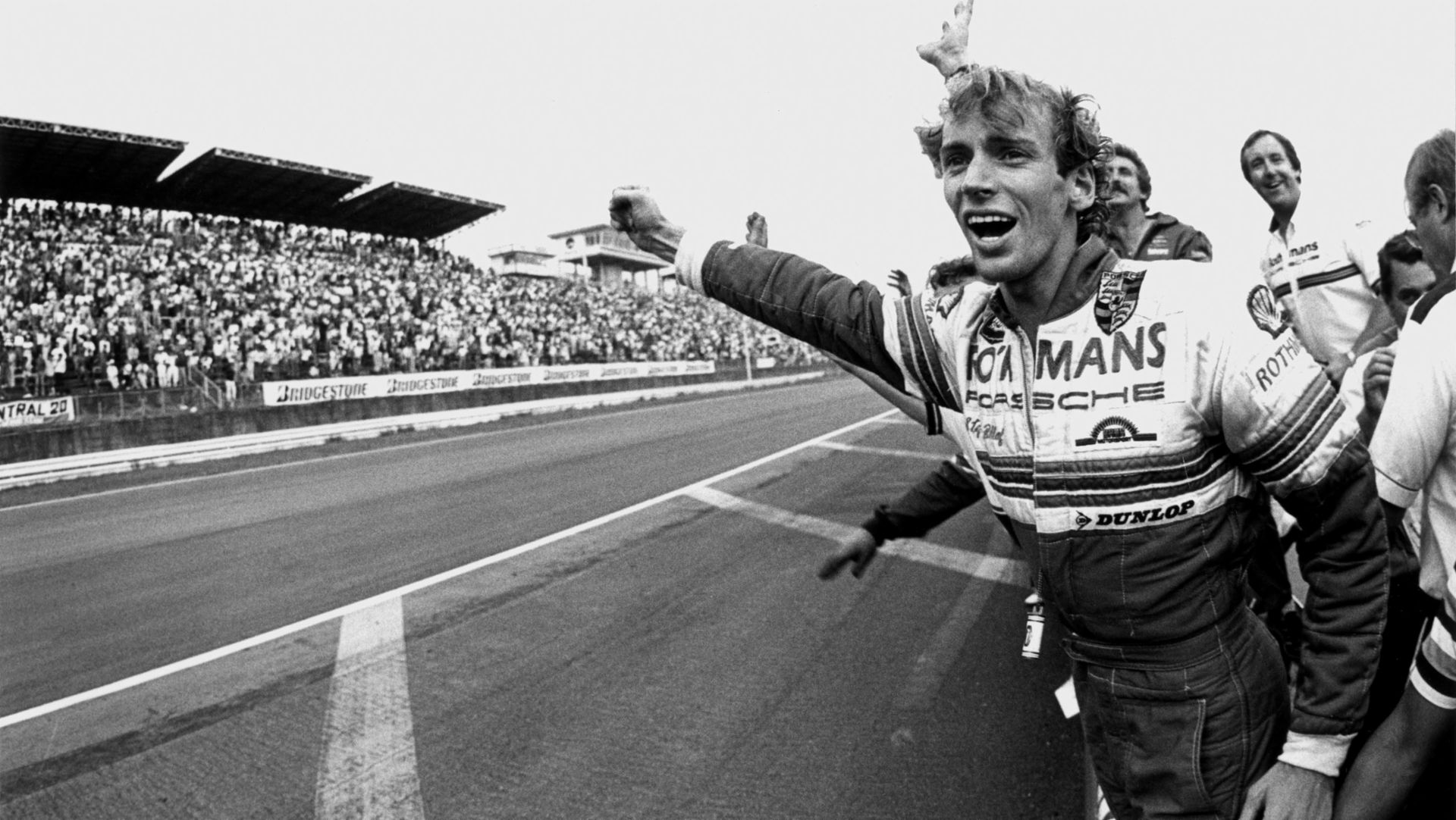 Stefan Bellof on side of racetrack, holding out his fist in triumph