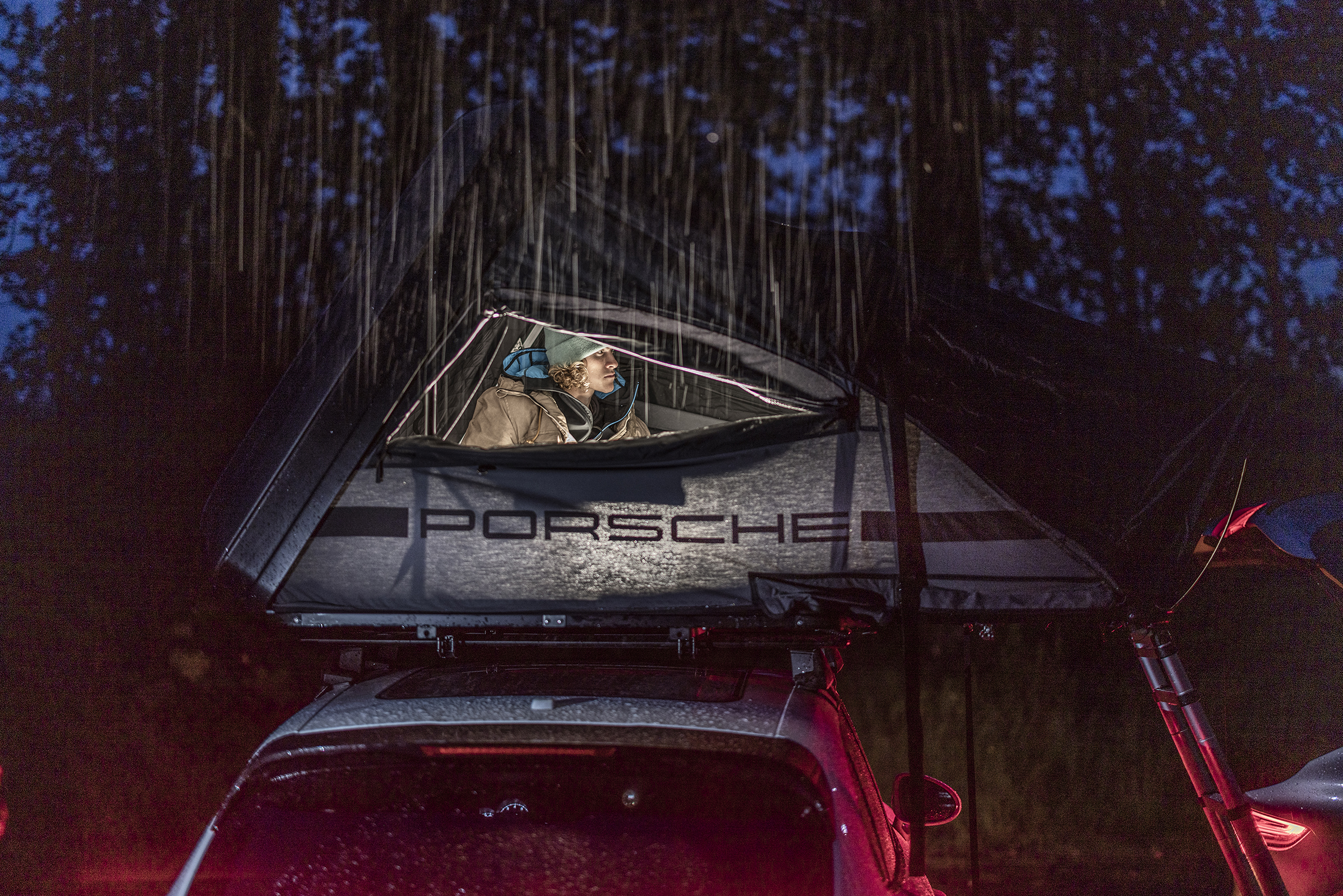 Kitesurfer Liam Whaley sitting in Porsche roof tent