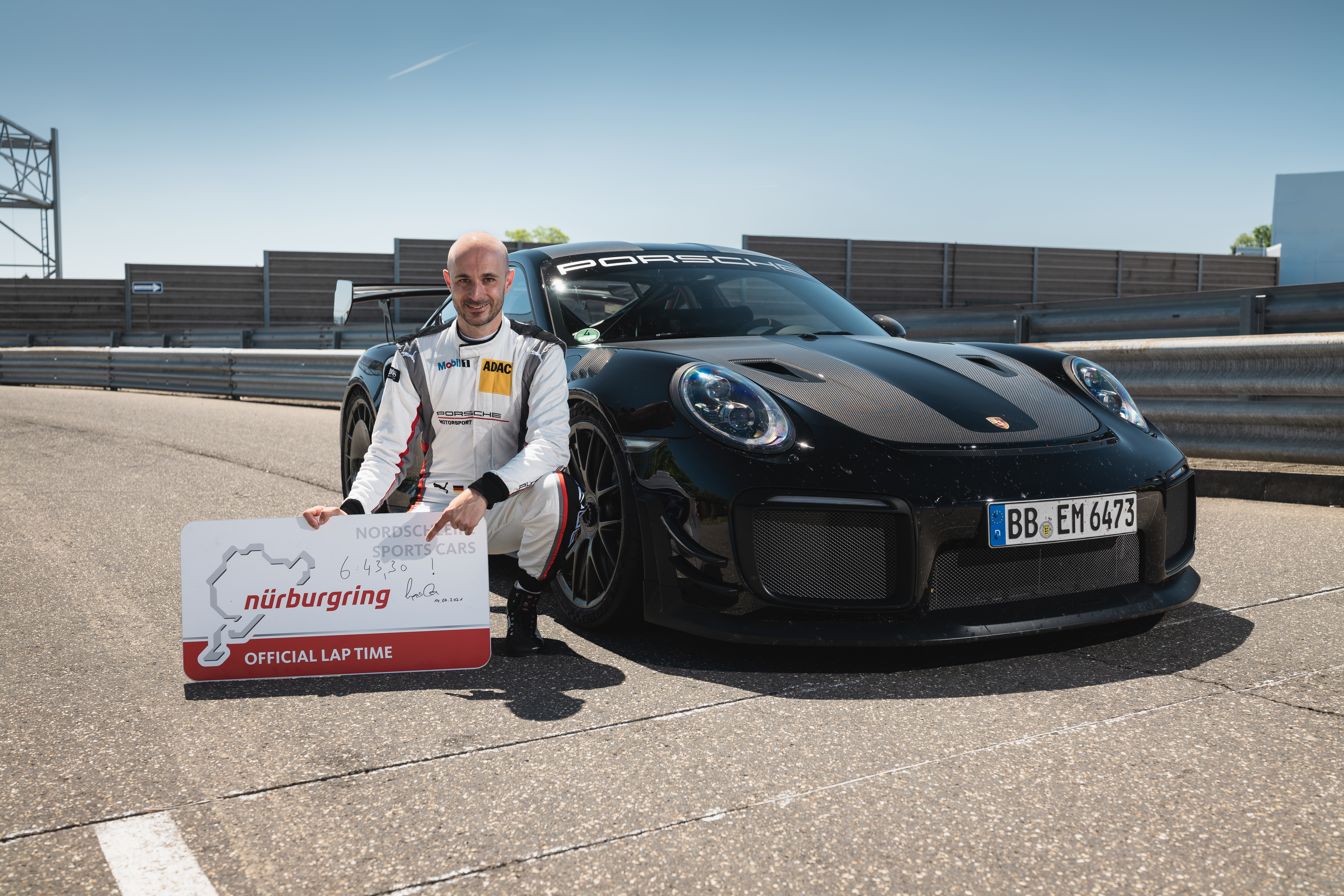 Race driver with Porsche 911 GT2 RS static on track