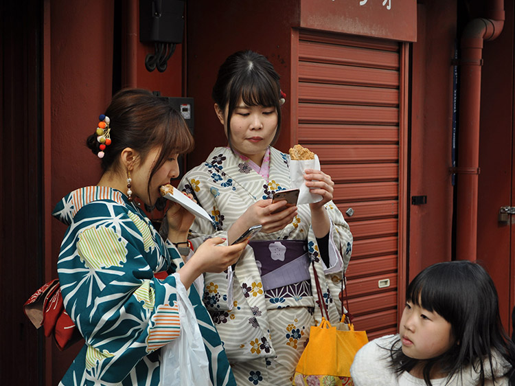 Two Japanese women in traditional dress with a young girl