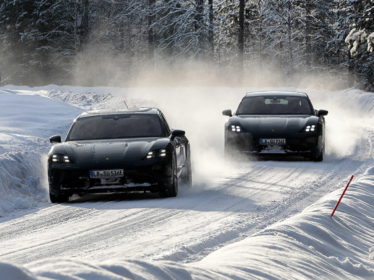 Two black Porsche Taycan cars in snow