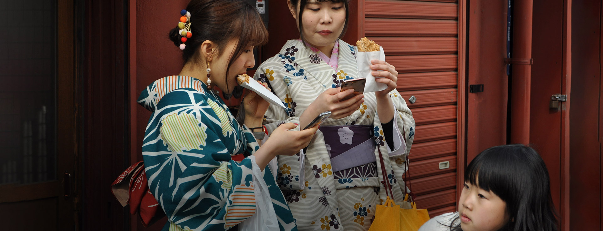 Two Japanese women in traditional dress with a young girl