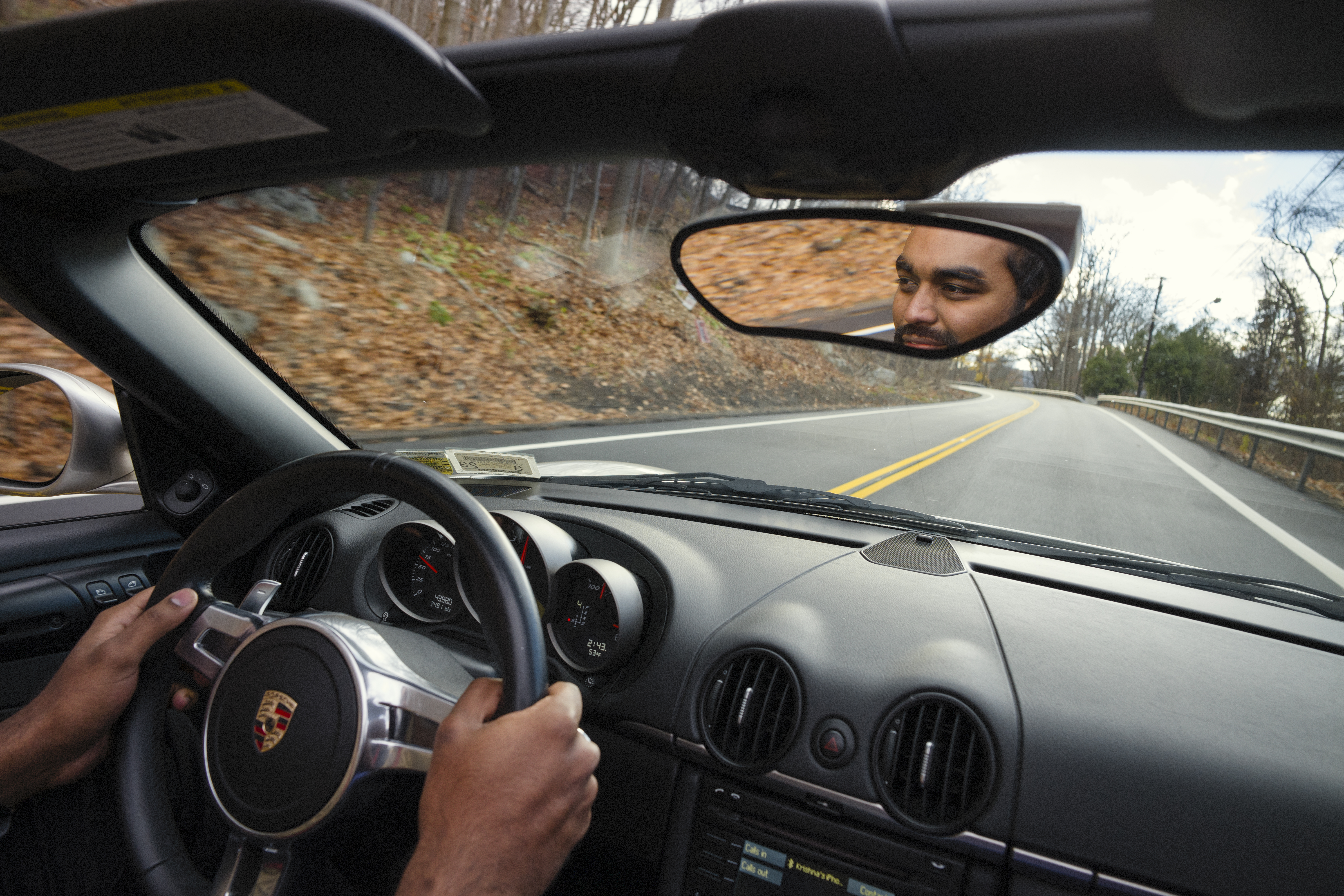View from inside the car of man driving Porsche Boxster Spyder