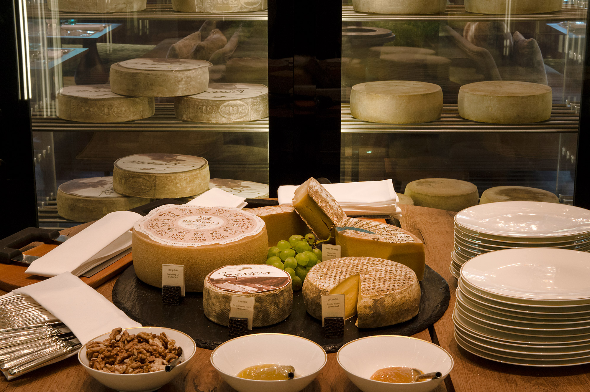 A spread of Swiss cheeses accompanied by grapes and plates