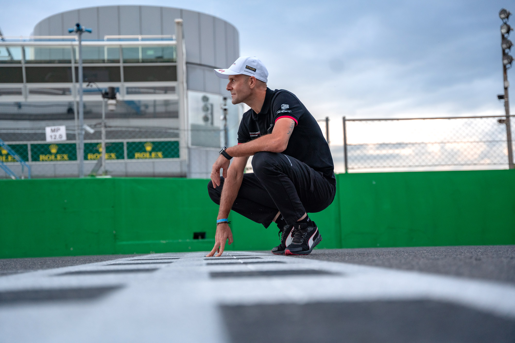 A man crouches at the start-finish straight in Monza