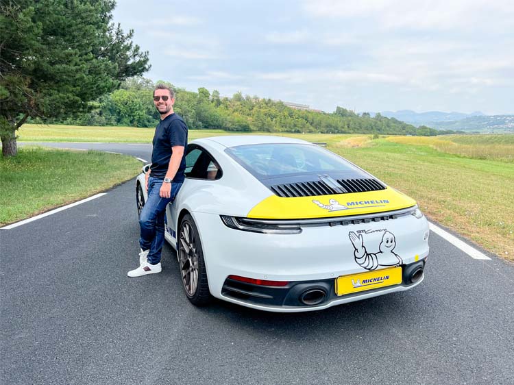 Man standing beside white Porsche 911
