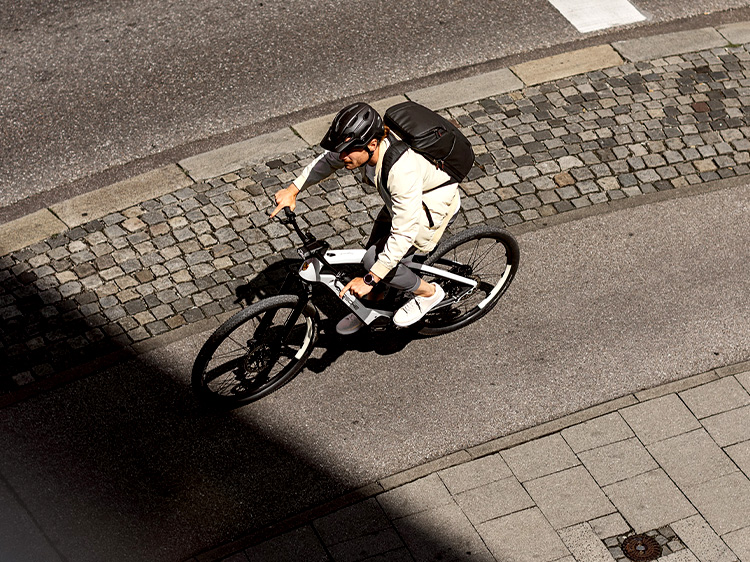 Porsche eBike leaning against brick wall next to Porsche Taycan