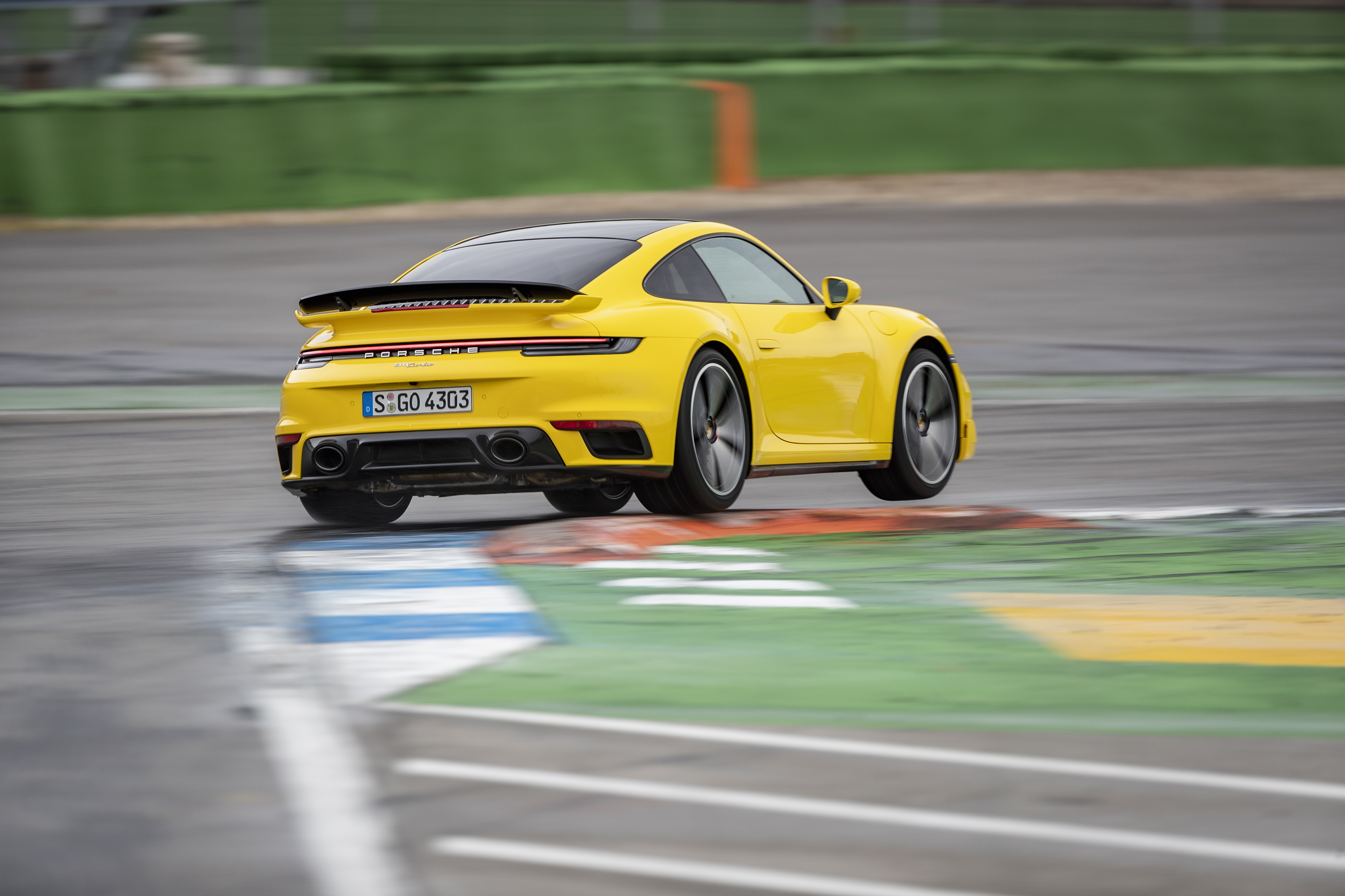 Yellow Porsche 911 Turbo (type 992) cornering on track