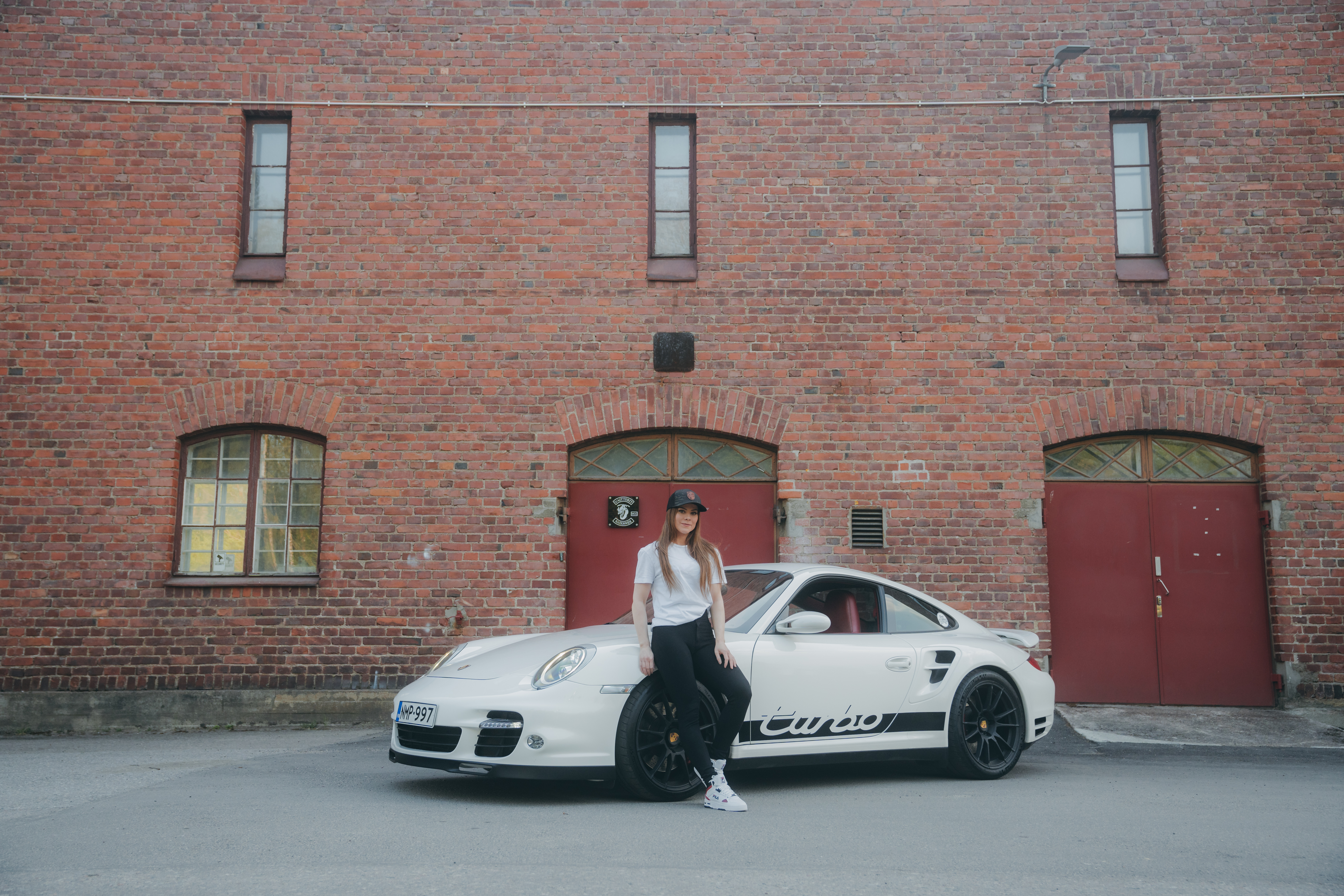 Woman leaning on white Porsche 911 Turbo (type 997)
