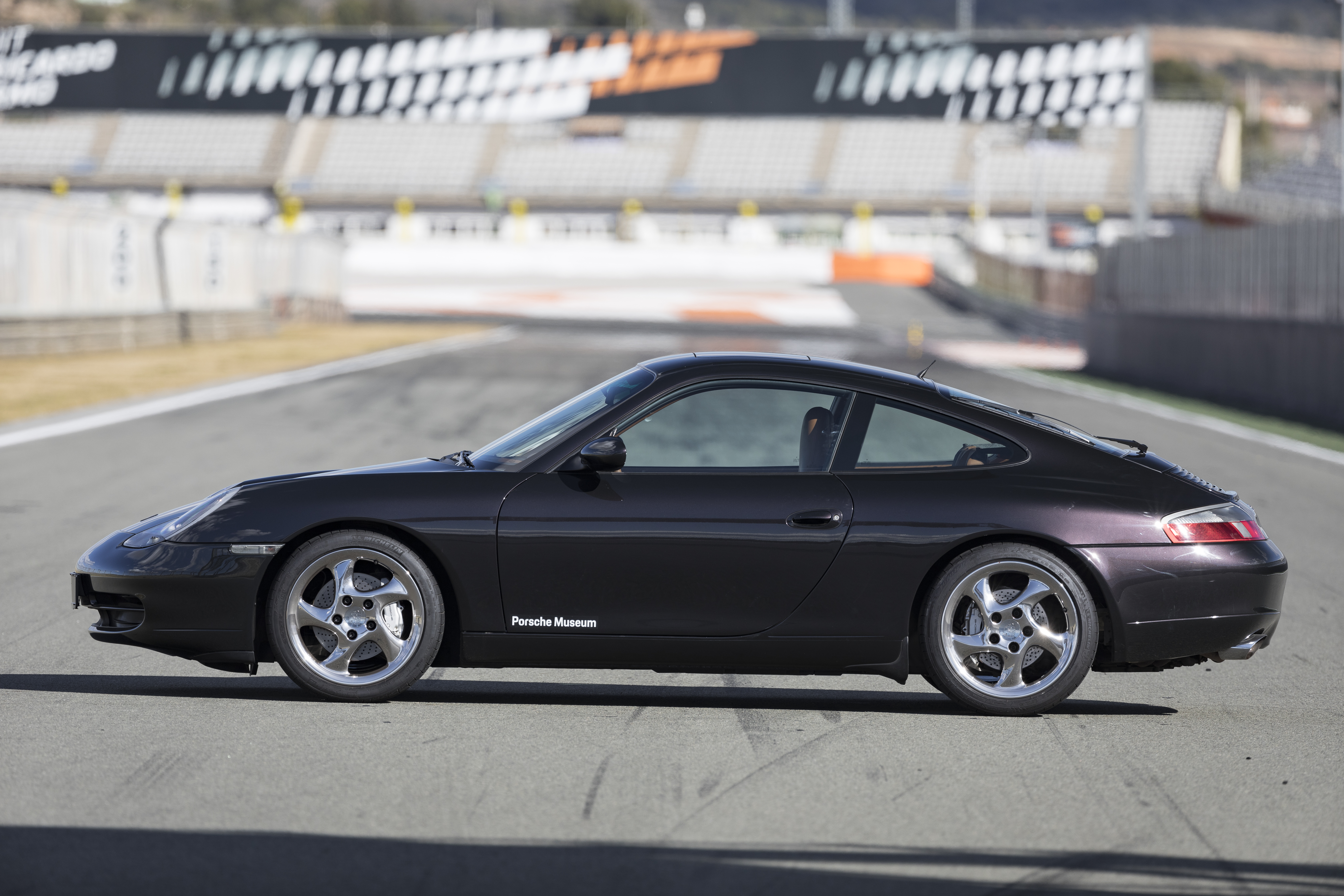 Side view of black Porsche 911 (996) parked on racetrack