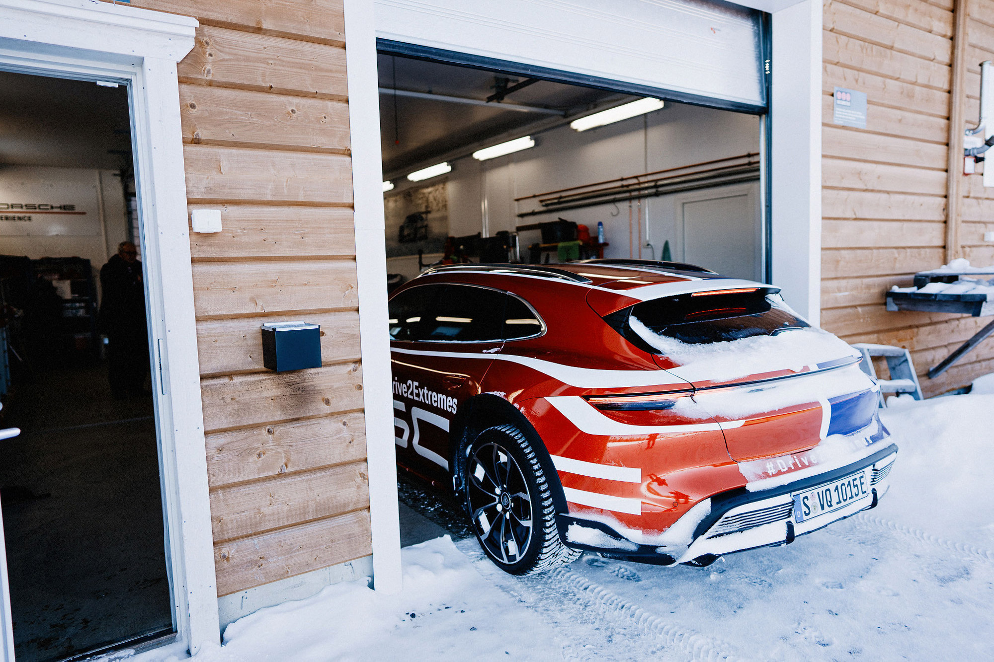 A Porsche Taycan Cross Turismo drives into a workshop