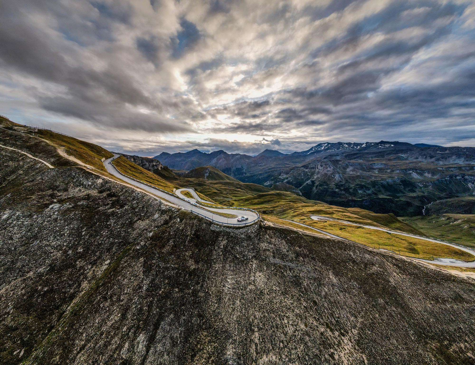Panoramic view of mountain roads and Alps under grey skies