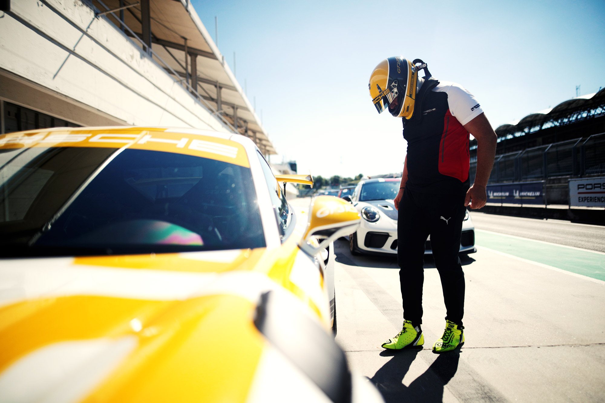 A driver stands next to a Porsche 911 GT3 RS