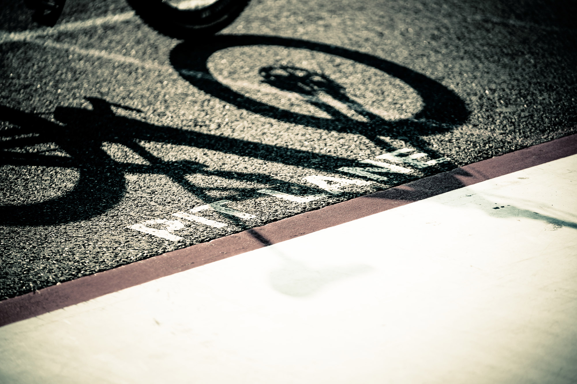 Pit lane sign on tarmac with shadow of bicycle