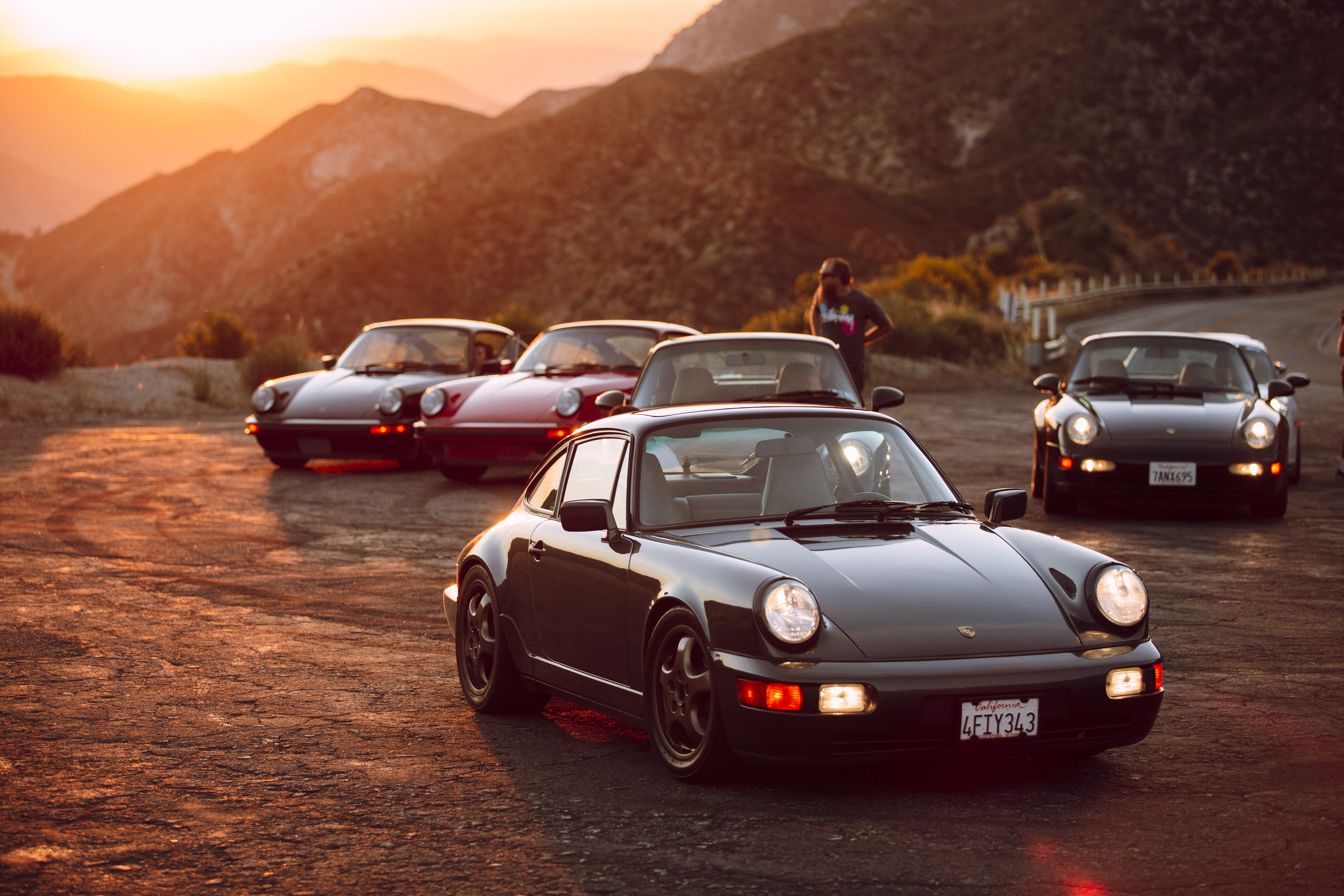 Collection of classic Porsche cars at sunset in California