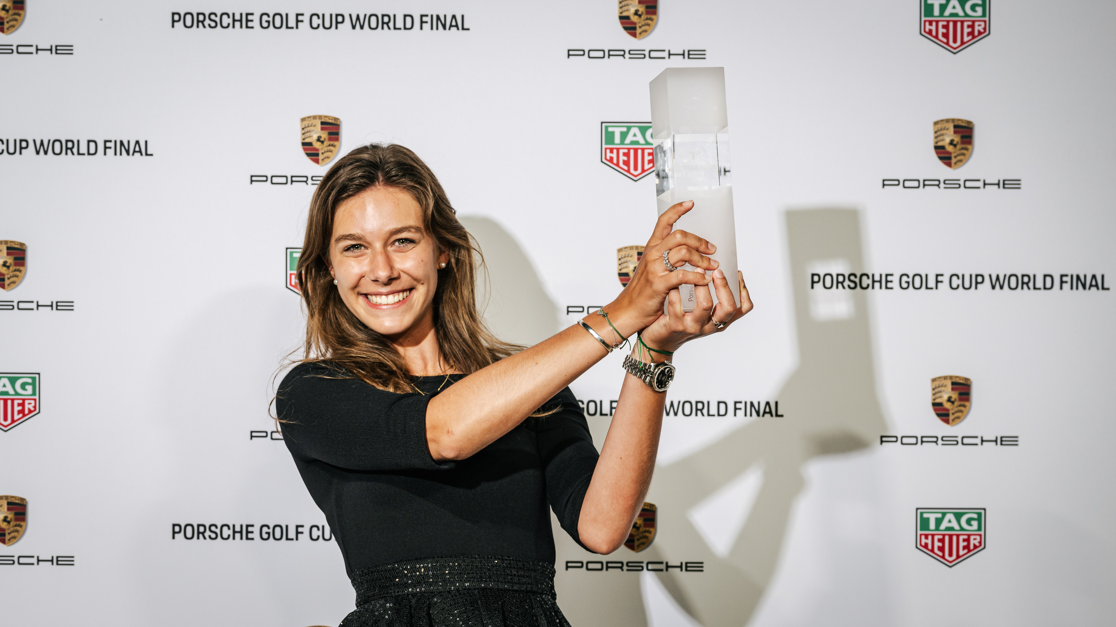Woman holds Porsche Golf Cup World Final aloft