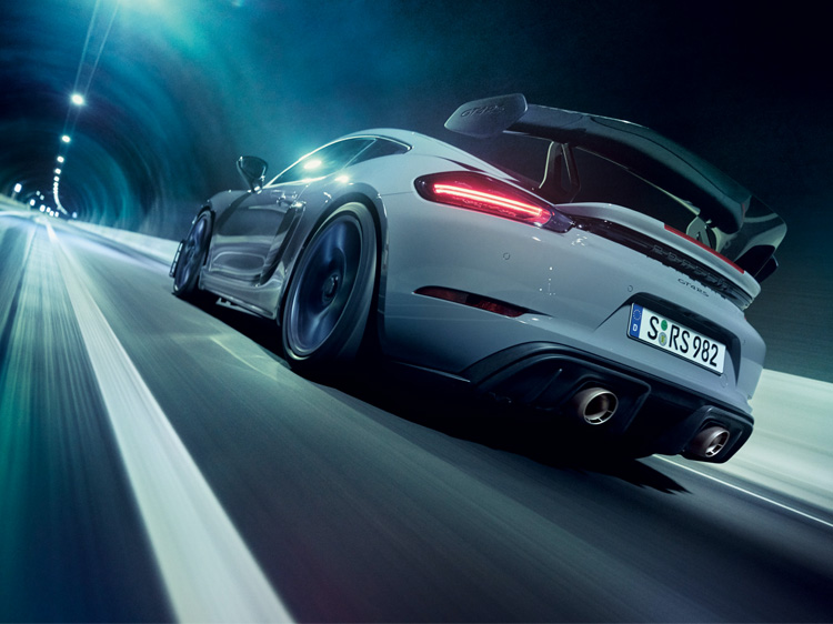 Rear view of Porsche 718 Cayman GT4 RS driving in a tunnel