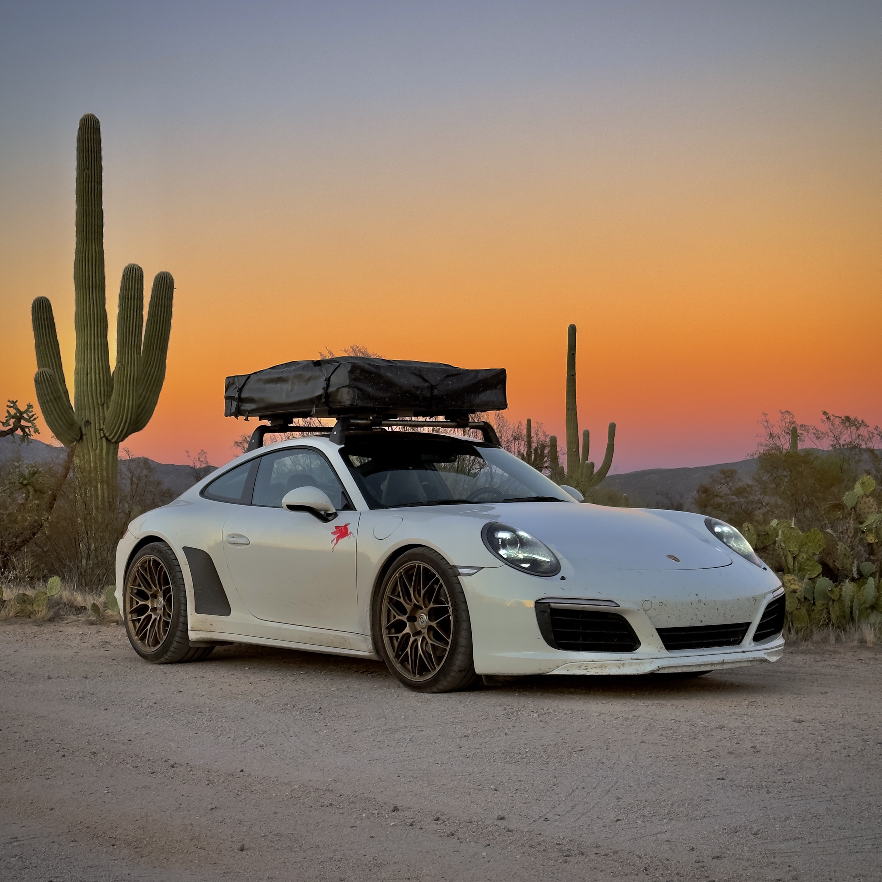 White Porsche 911 Carrera at sunset in the desert