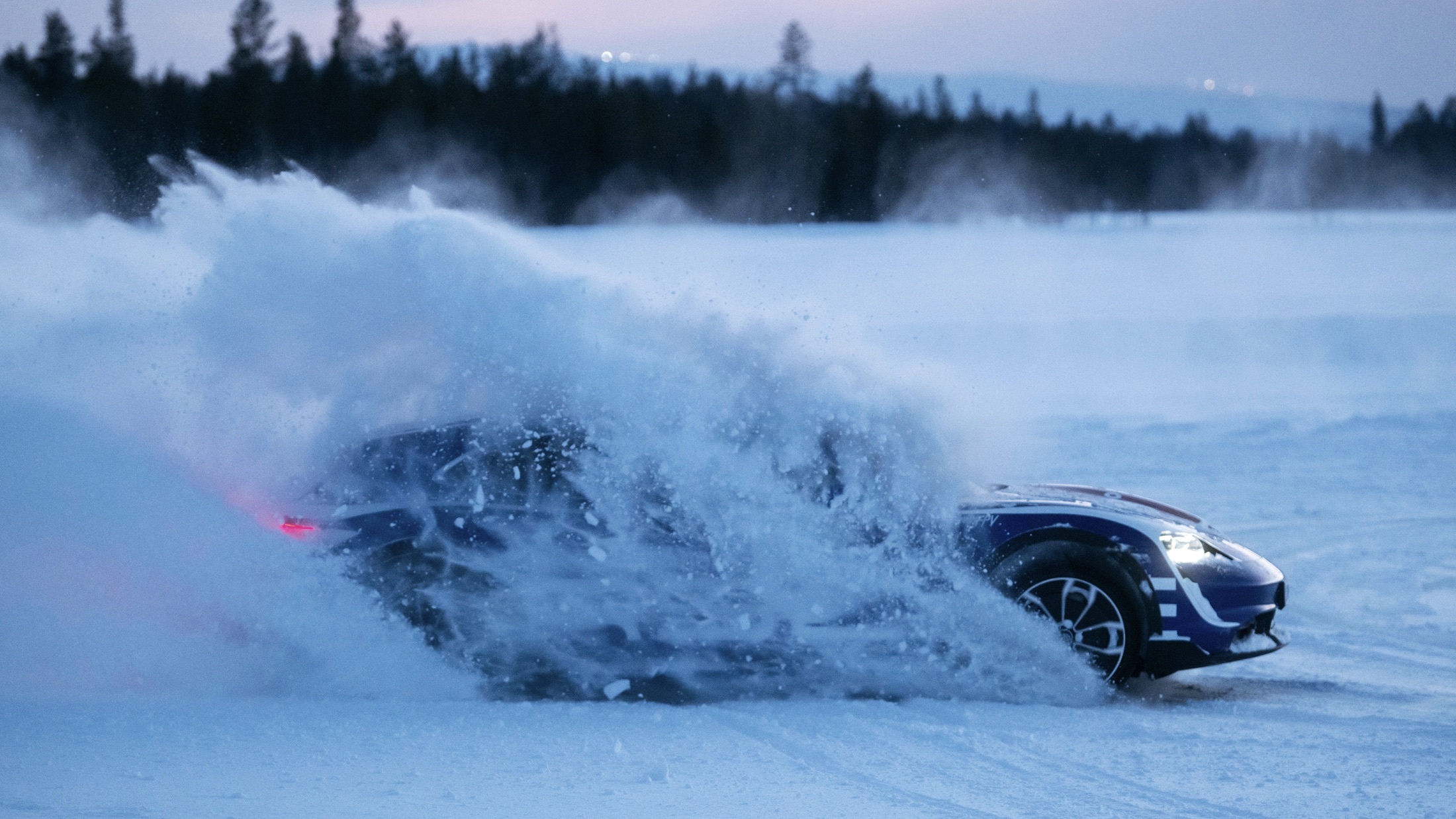 Porsche Taycan drifting in the snow, forest in background