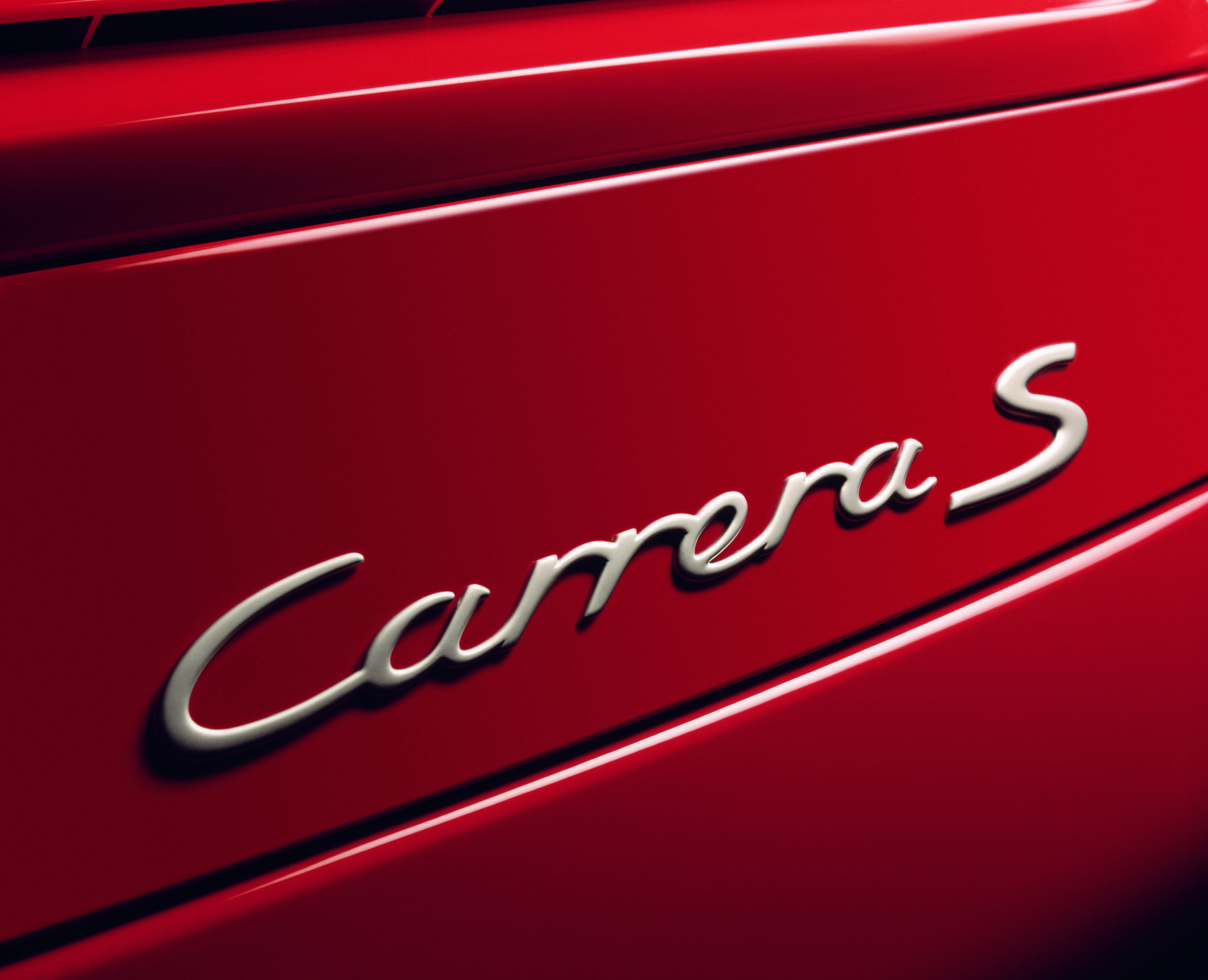 Close-up picture of a Porsche 911 Carrera S badge on the back of car