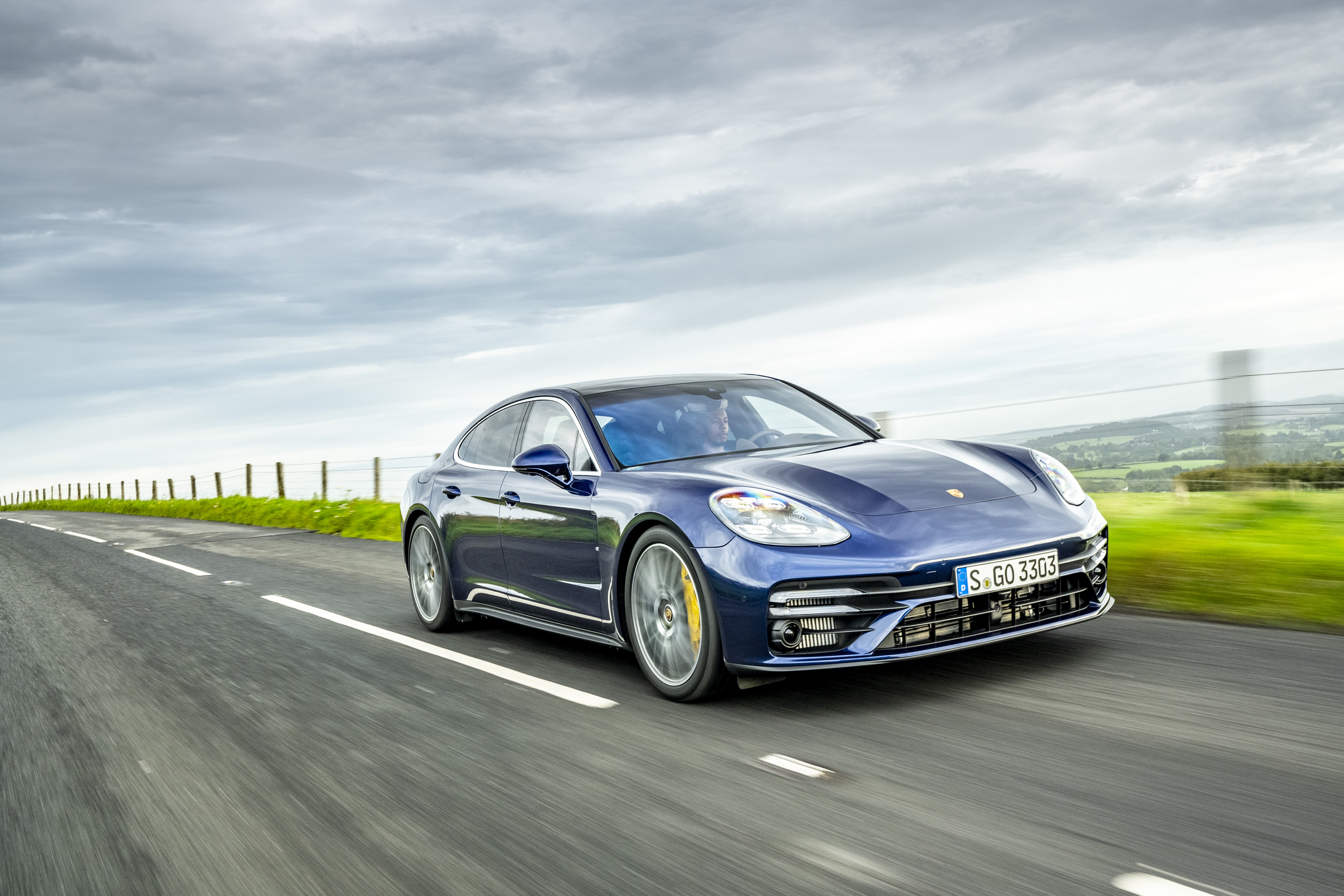 Blue Porsche Panamera Turbo S driving on a rural road