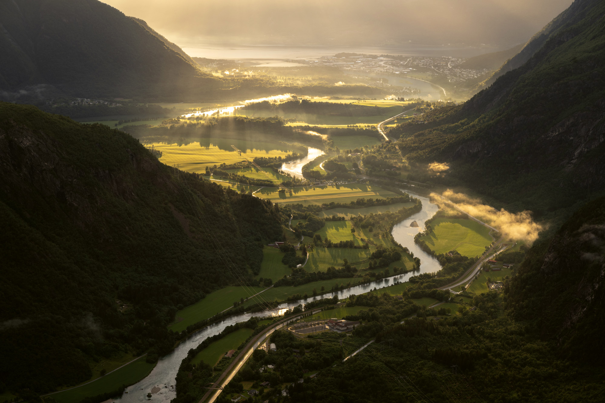 River running through lush Norwegian landscape at sunset
