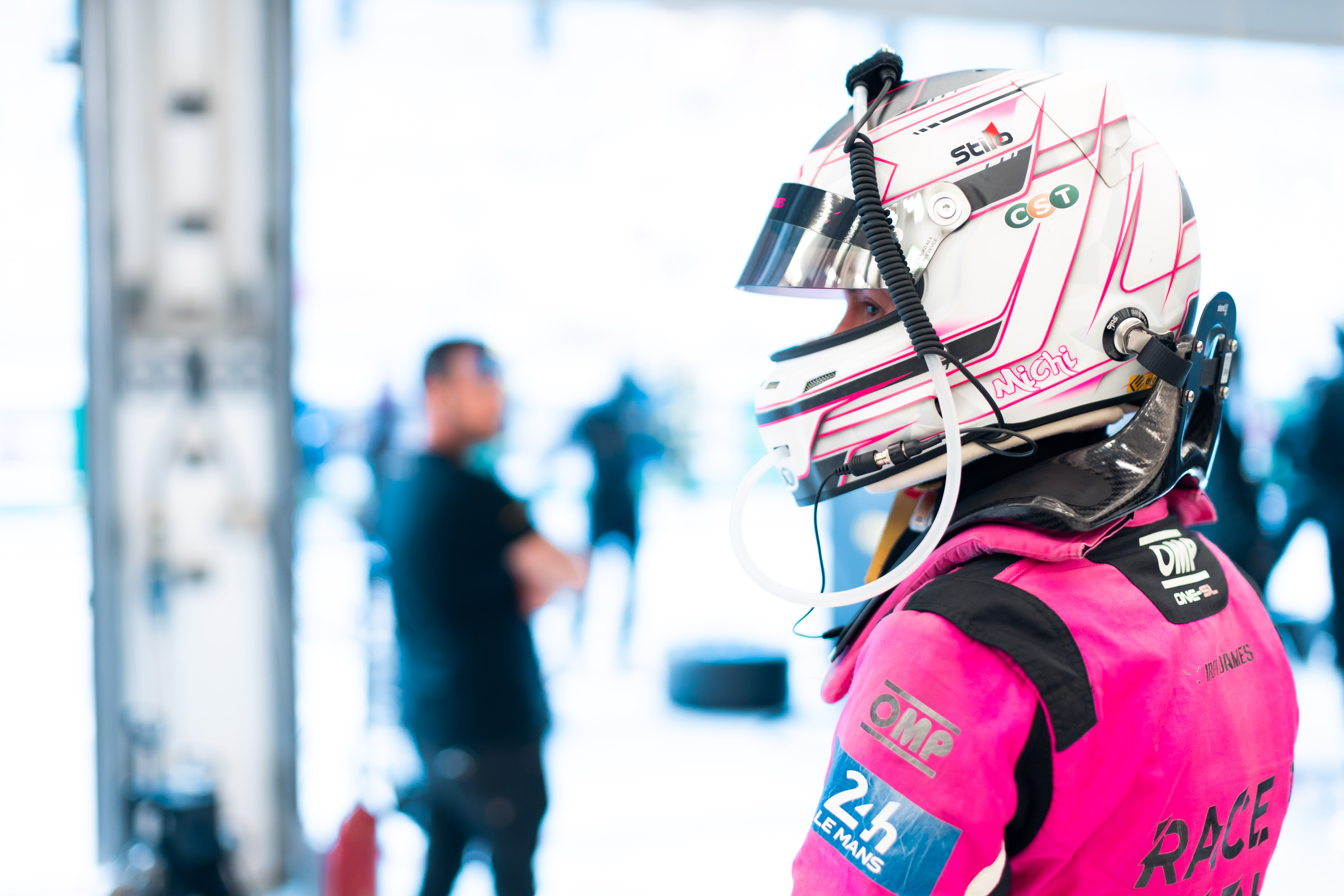 Racing driver in pink suit with helmet, preparing for race