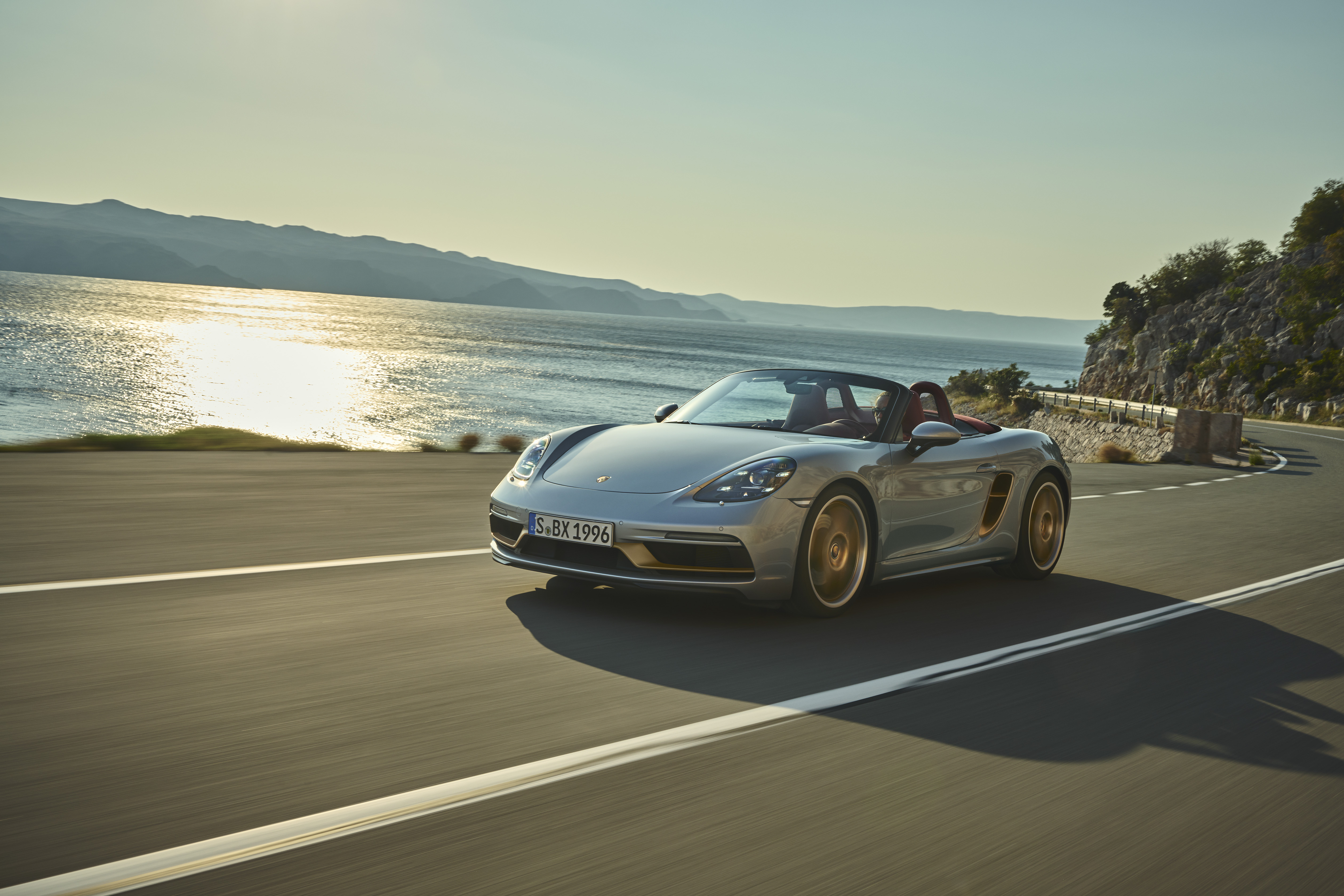 Boxster 25 Years on the road by ocean at sunset
