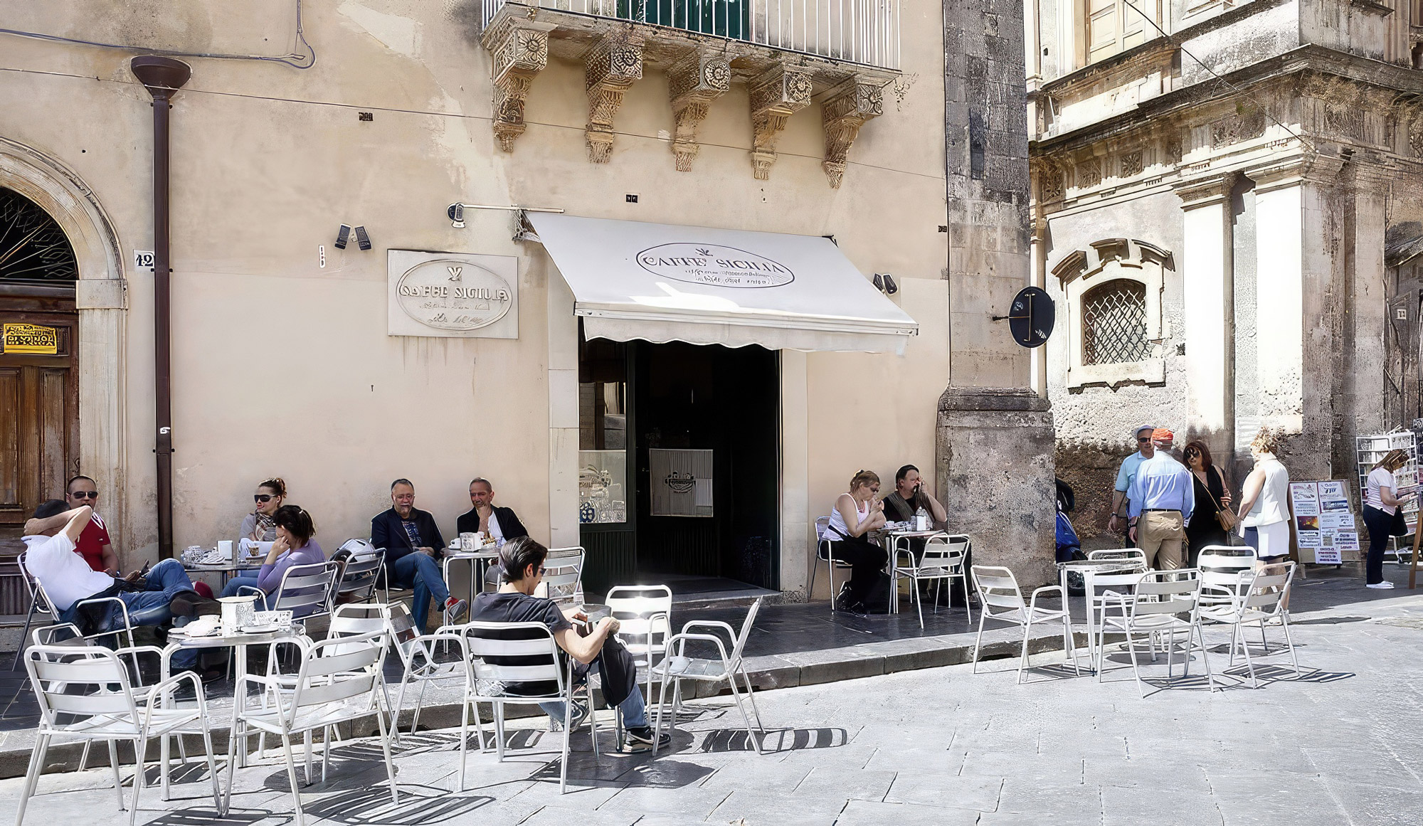 People sitting outside café on a sunny Sicilian street