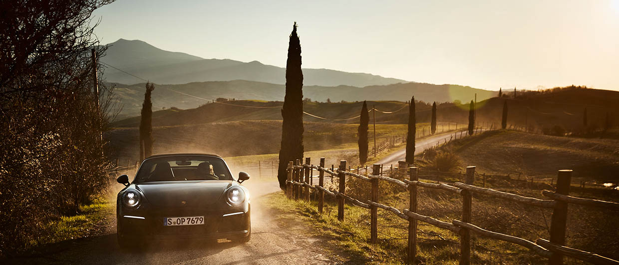 Frontside of a Porsche driving in Italian landscape
