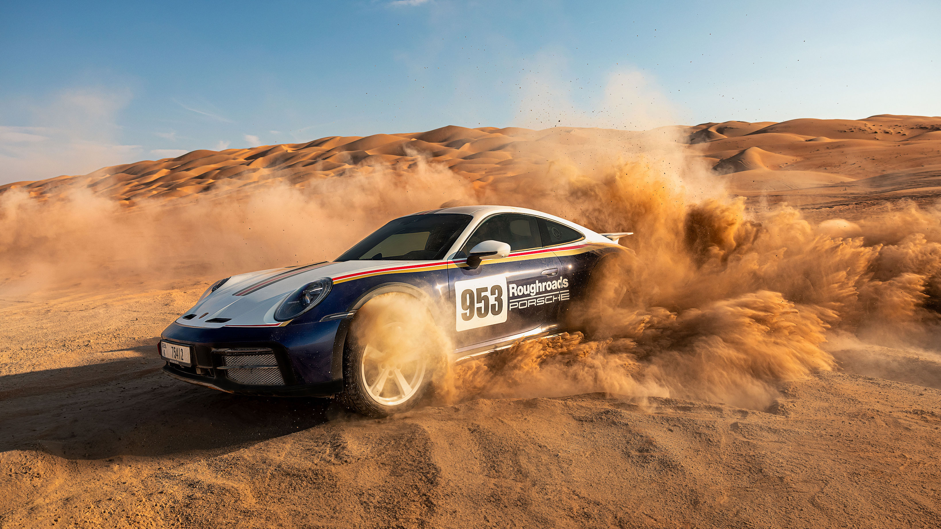 Porsche 911 Dakar racing in desert, dunes in background