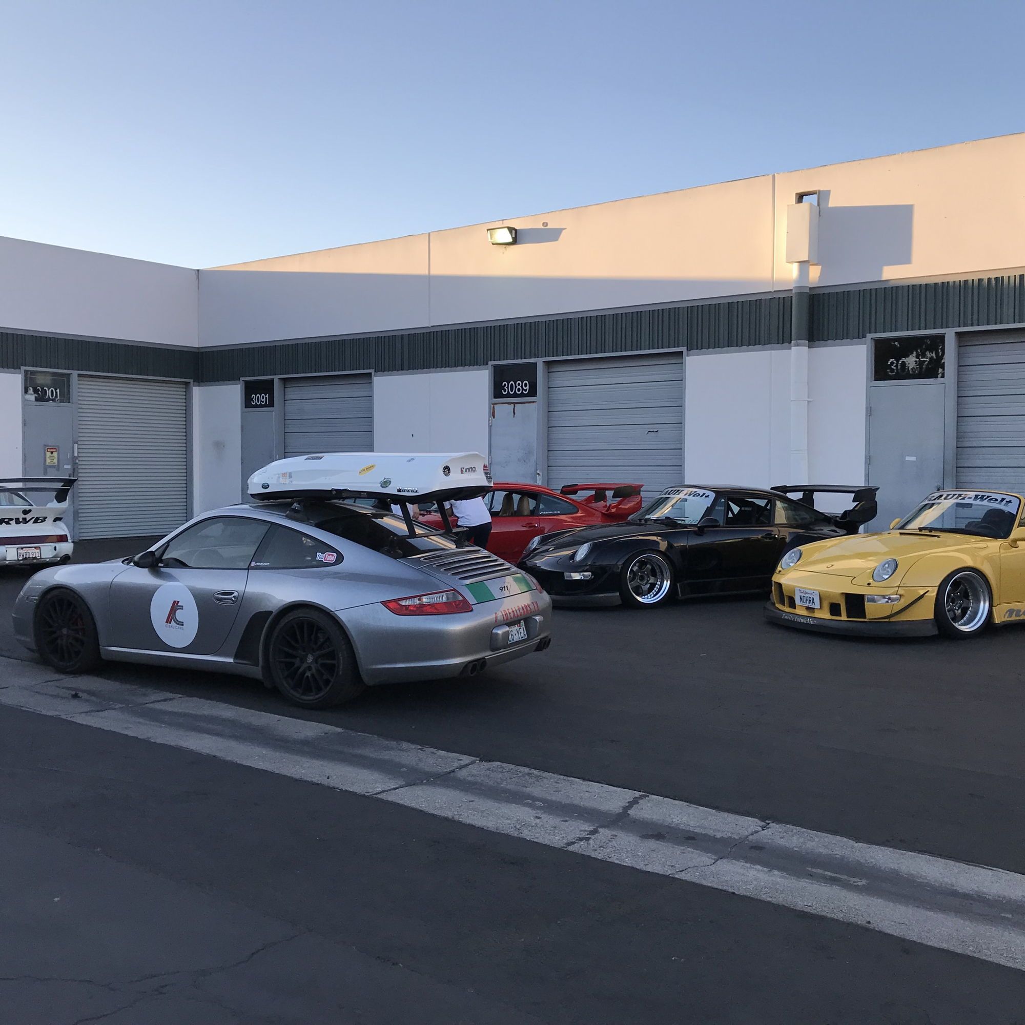 Silver Porsche 911 with surrounded by other classic 911s