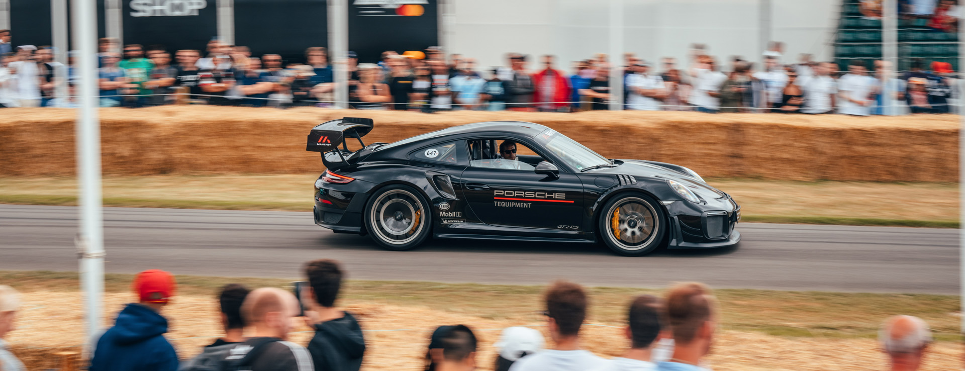 Porsche GT2 RS speeding past crowds at Goodwood track