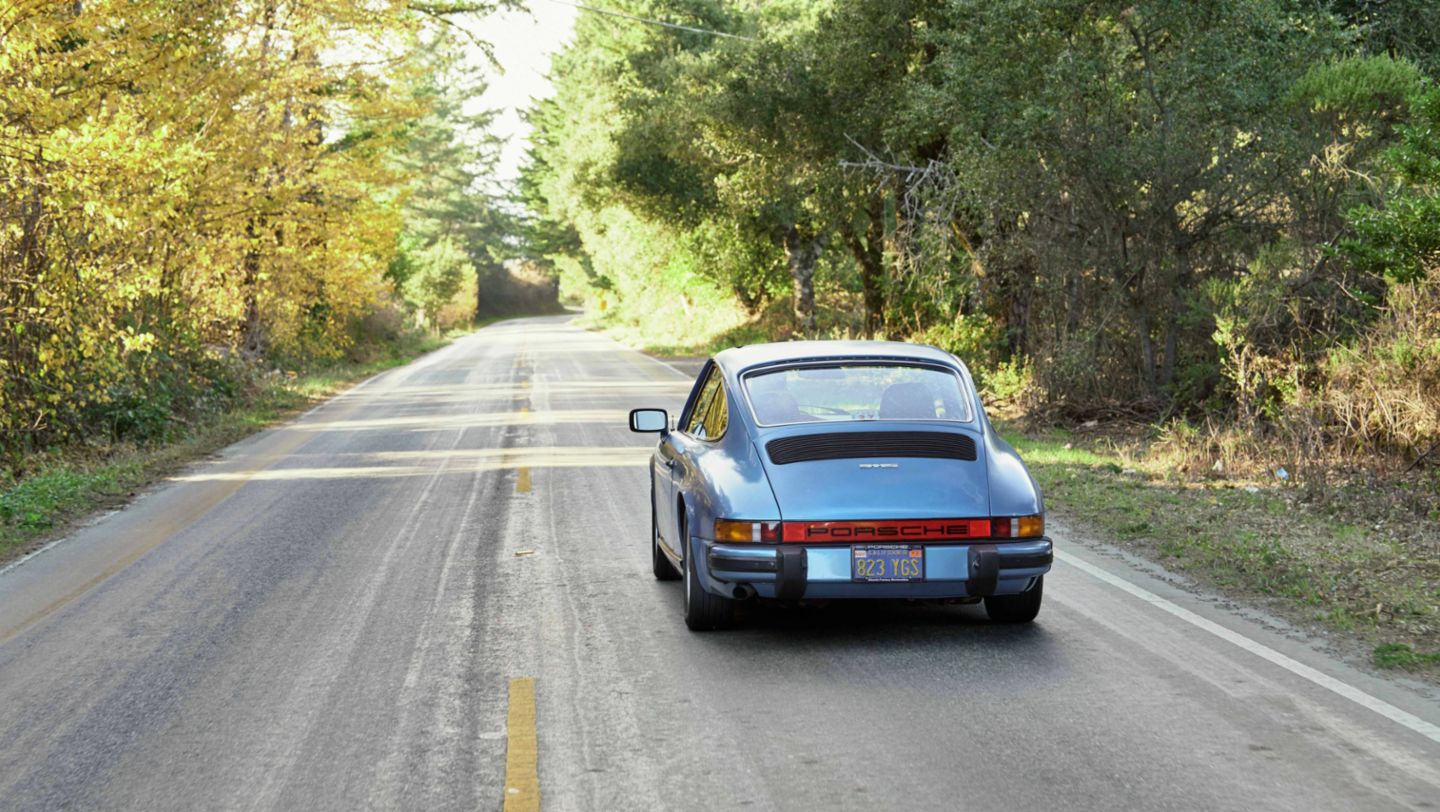 Rear view of Porsche 911 S on empty forest road
