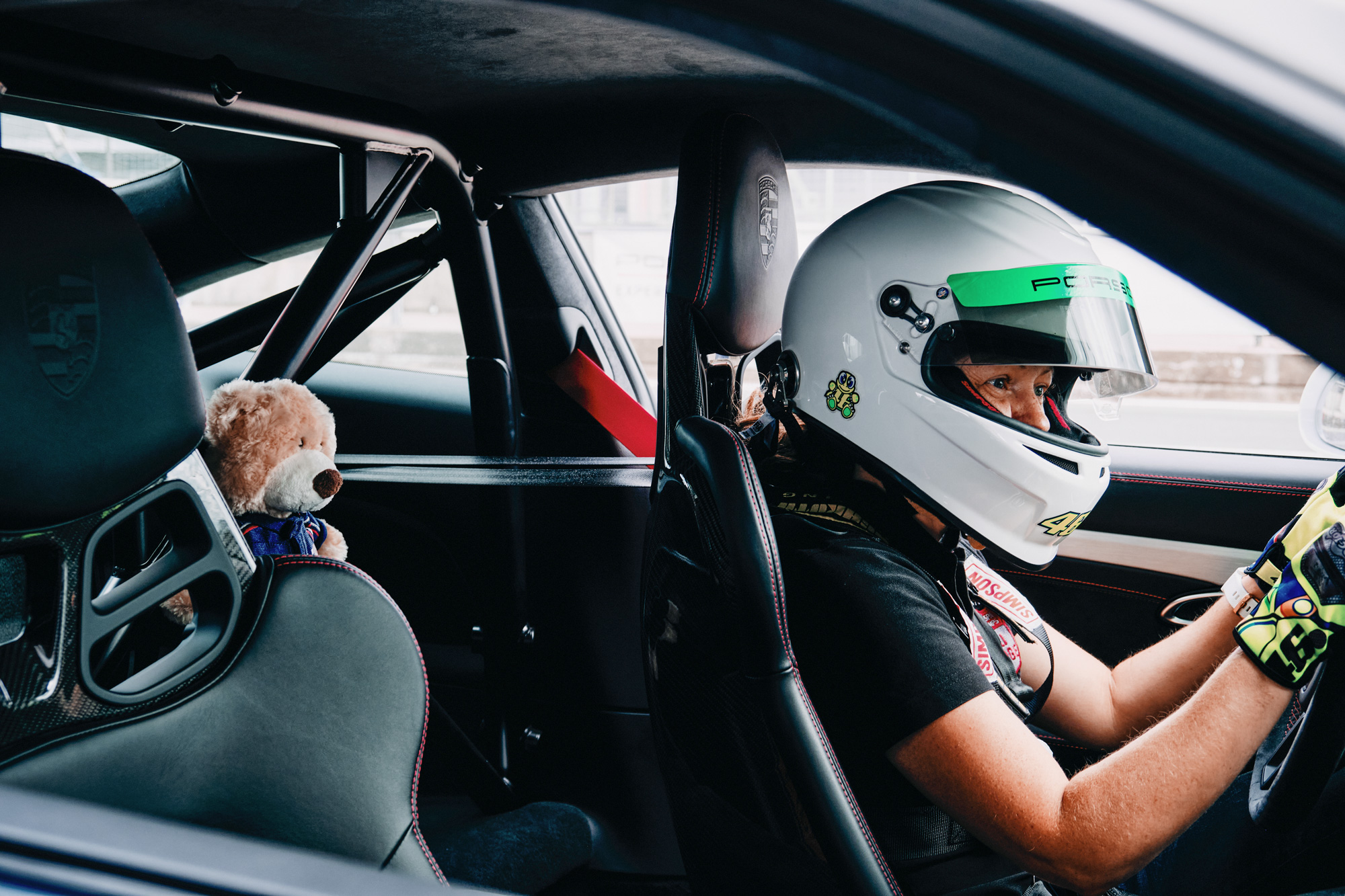 Race driver at the wheel, a teddy bear behind them