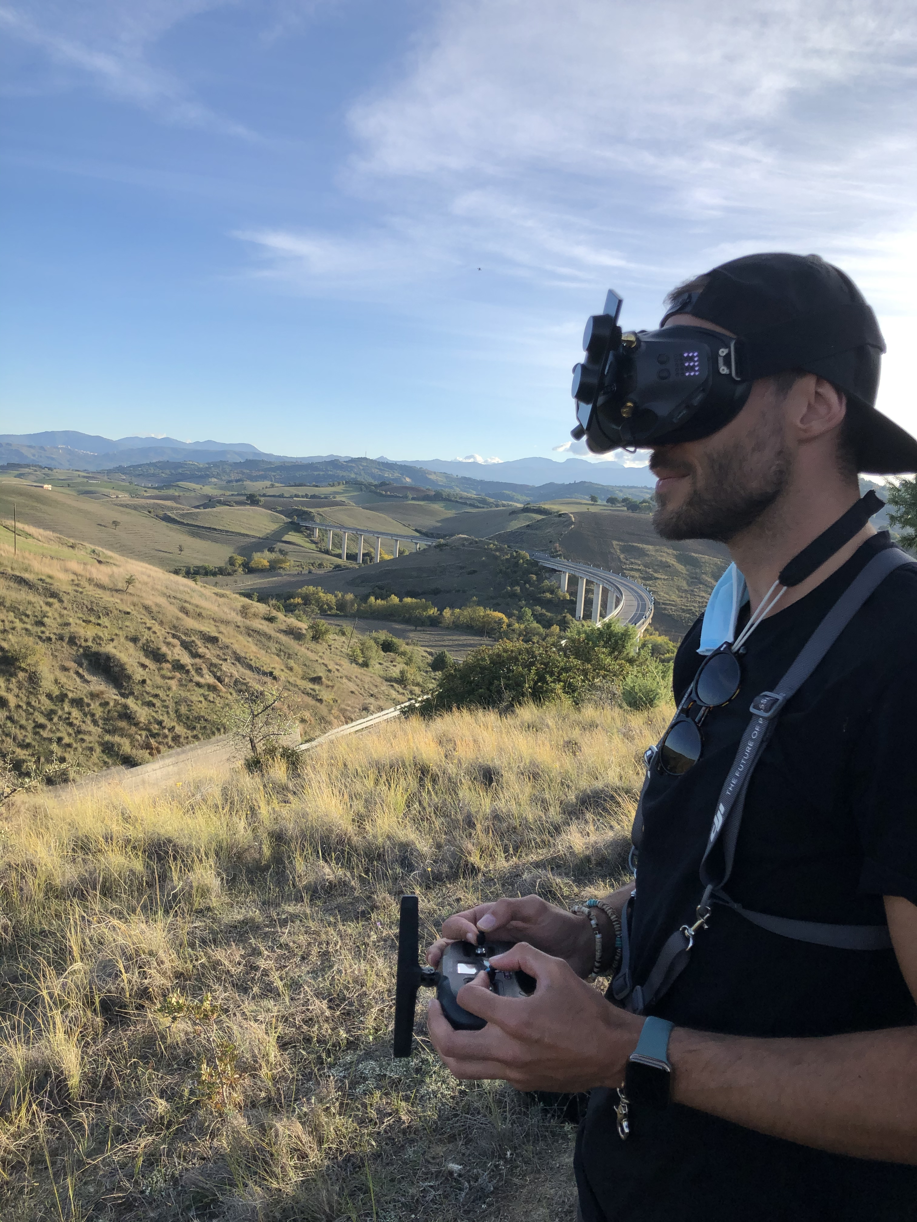 Man in VR goggles with road and hills in background