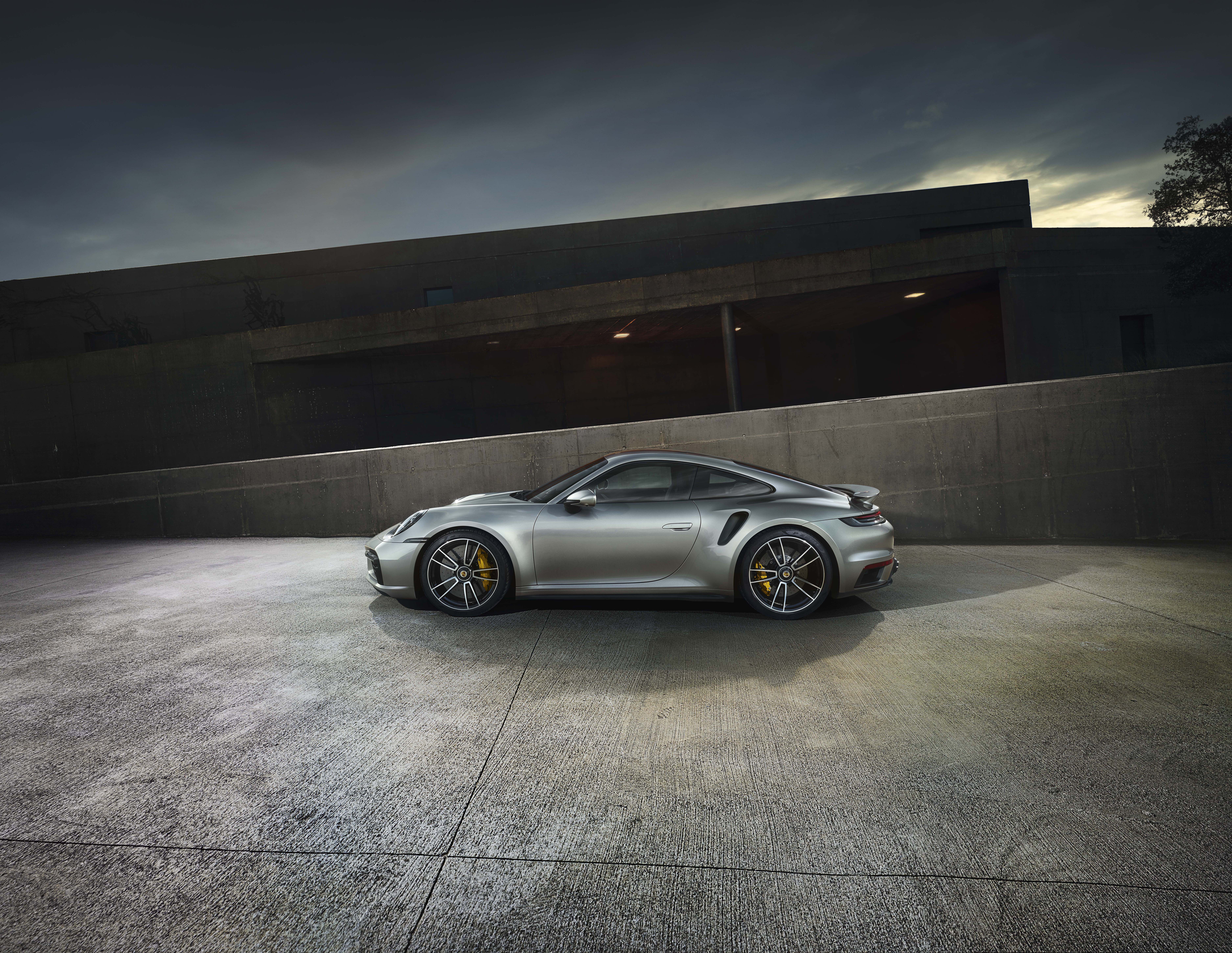 Silver Porsche 911 Turbo S (type 992) by modernist buildings