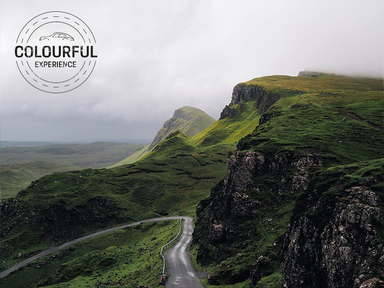 Winding mountainous Irish road passes rugged granite rocks