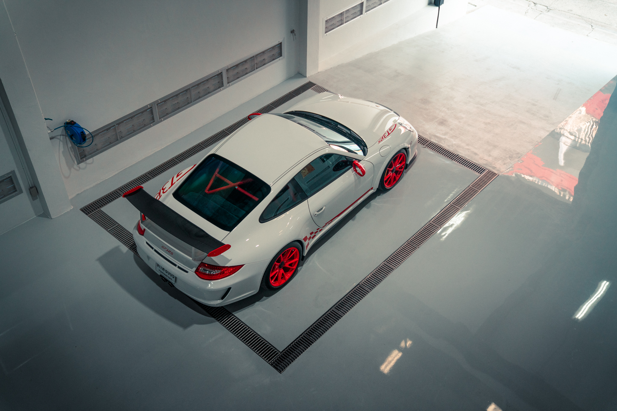 White Porsche 911 GT3 RS with red trim in garage