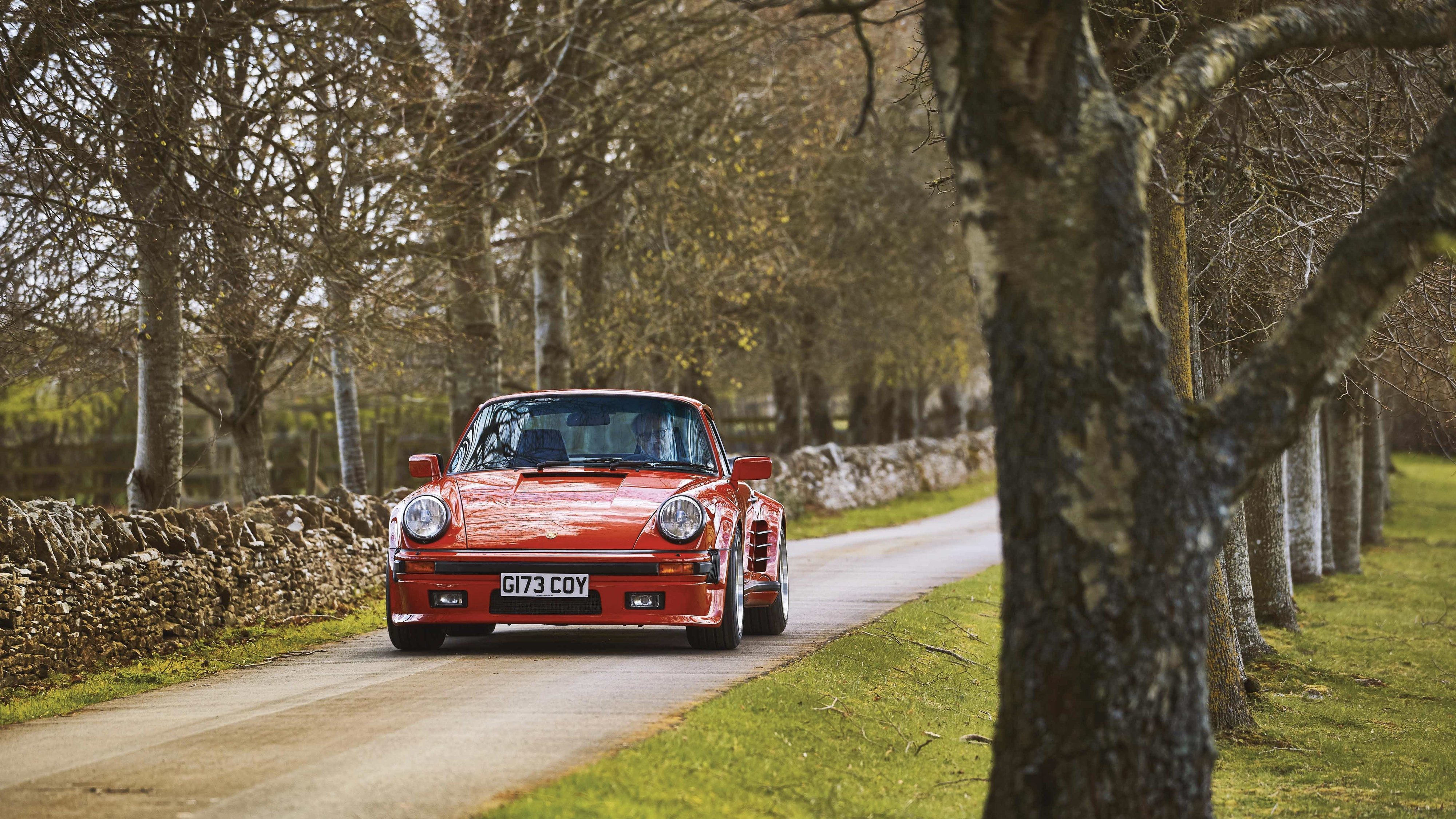 Porsche 930 Turbo S in Guards Red on tree-lined road