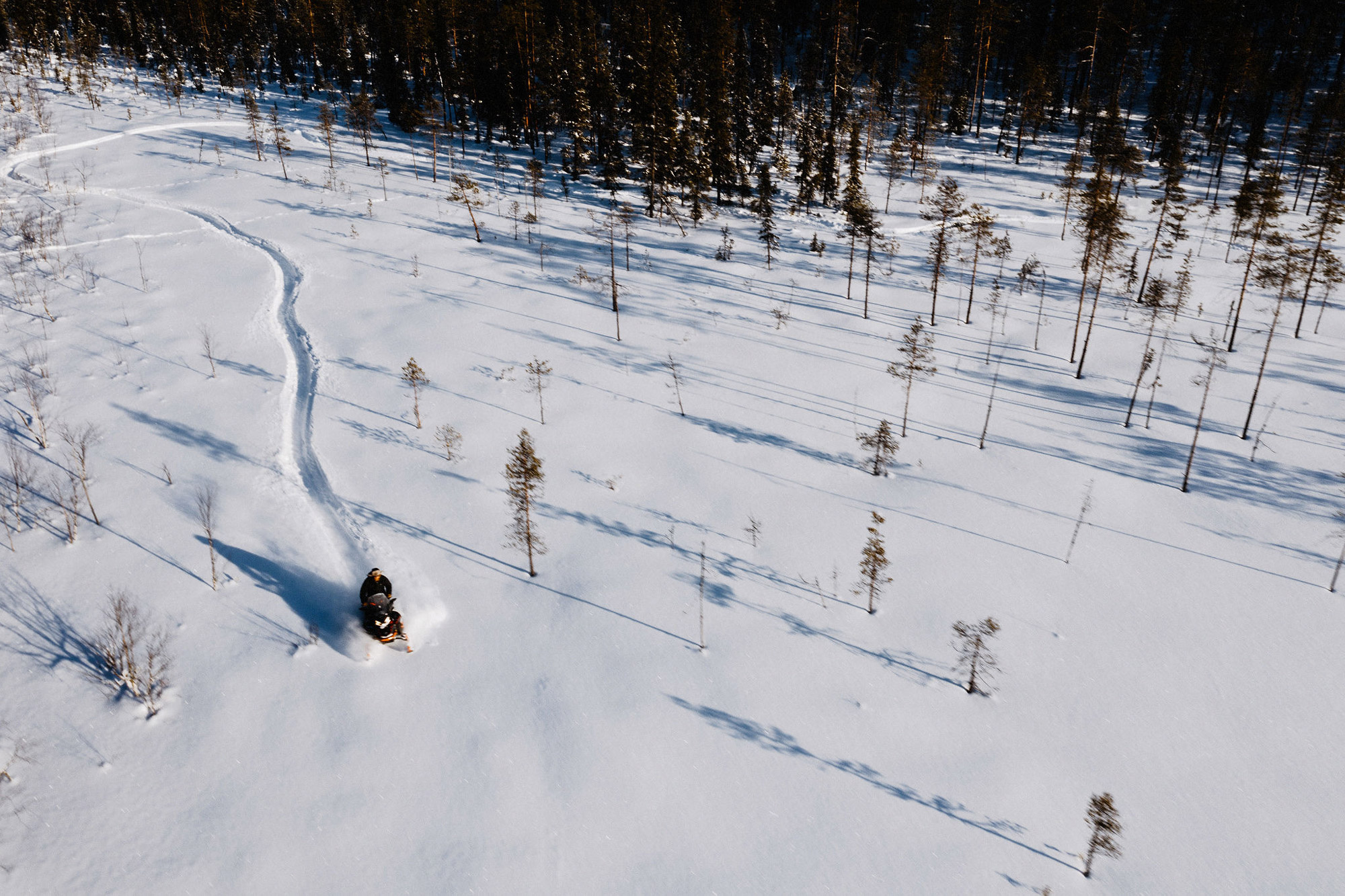 A man rides his snowmobile through the Finnish wilderness