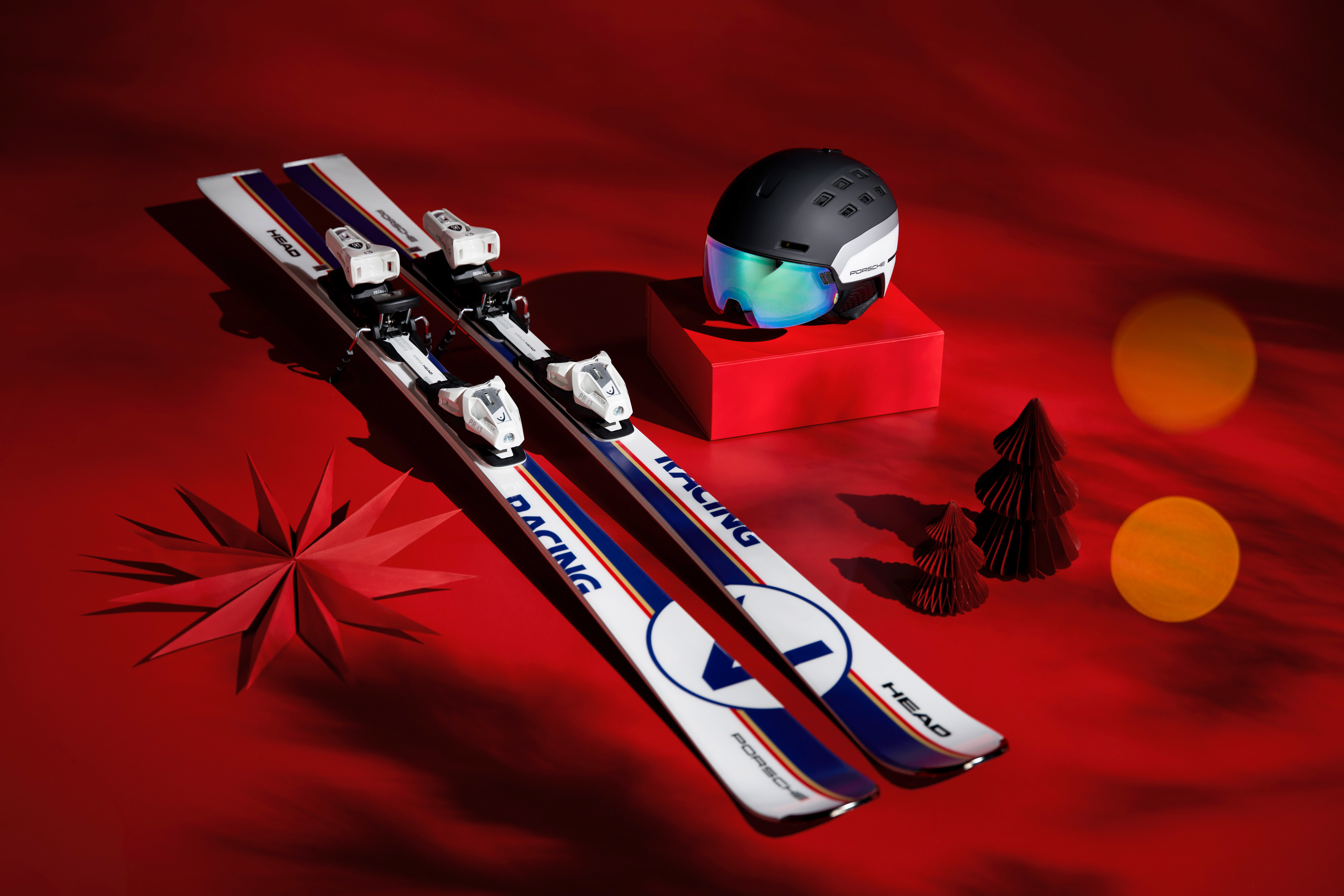 Porsche x HEAD skis and helmet on red background