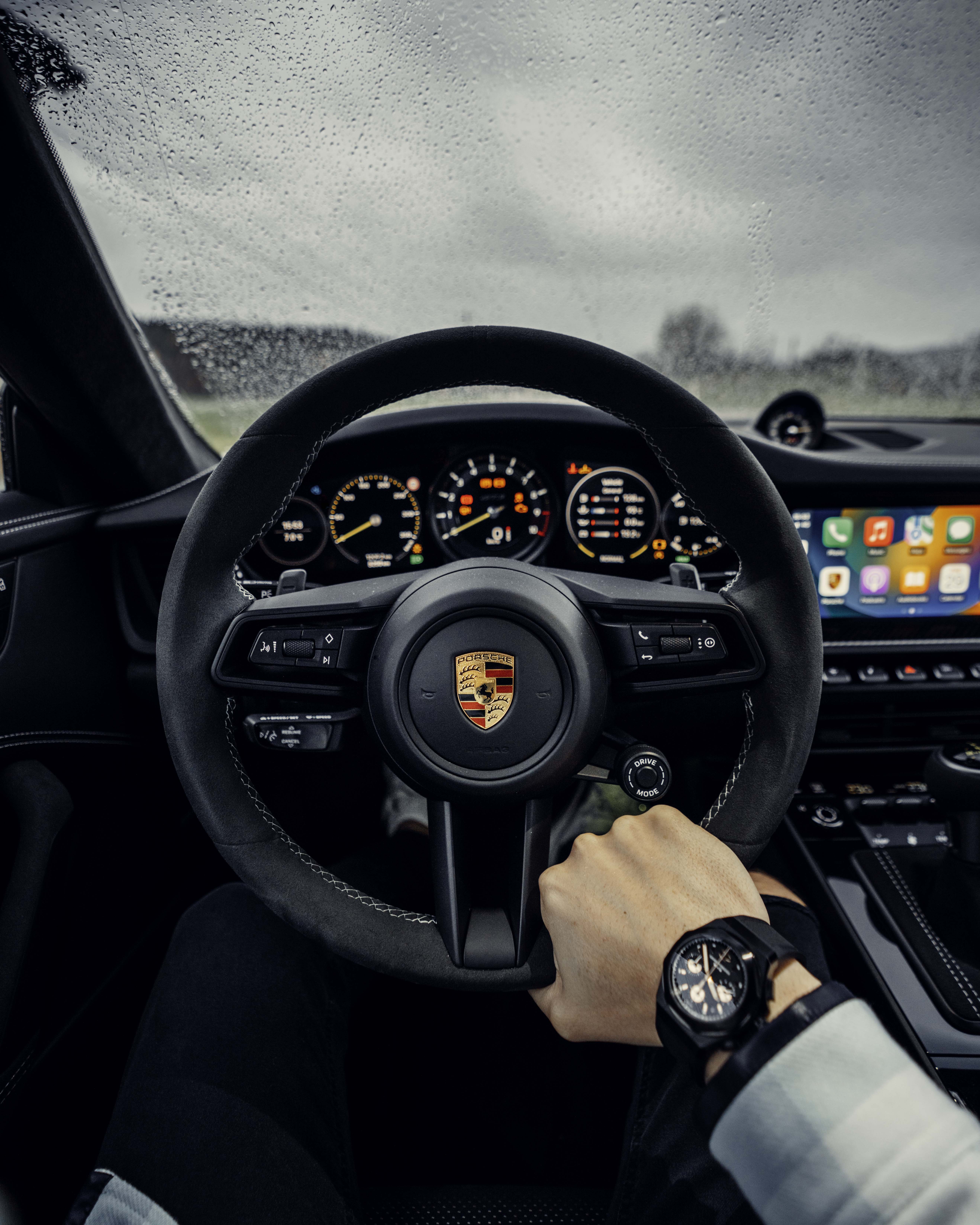 Man’s hand holding steering wheel of Porsche 911 GT3