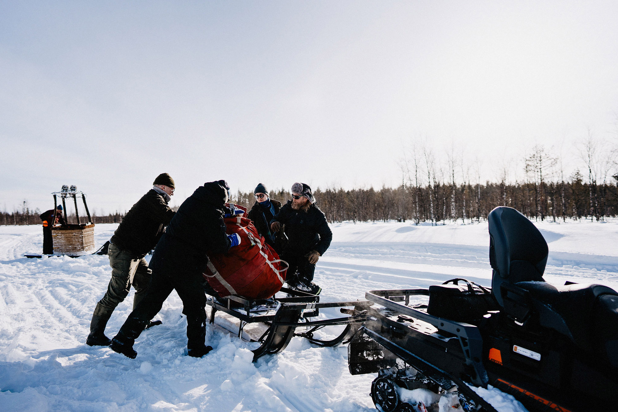 People loading a snowmobile trailer
