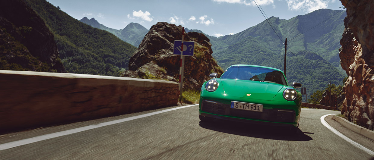 Python Green Porsche 911 Carrera T driving on mountain road