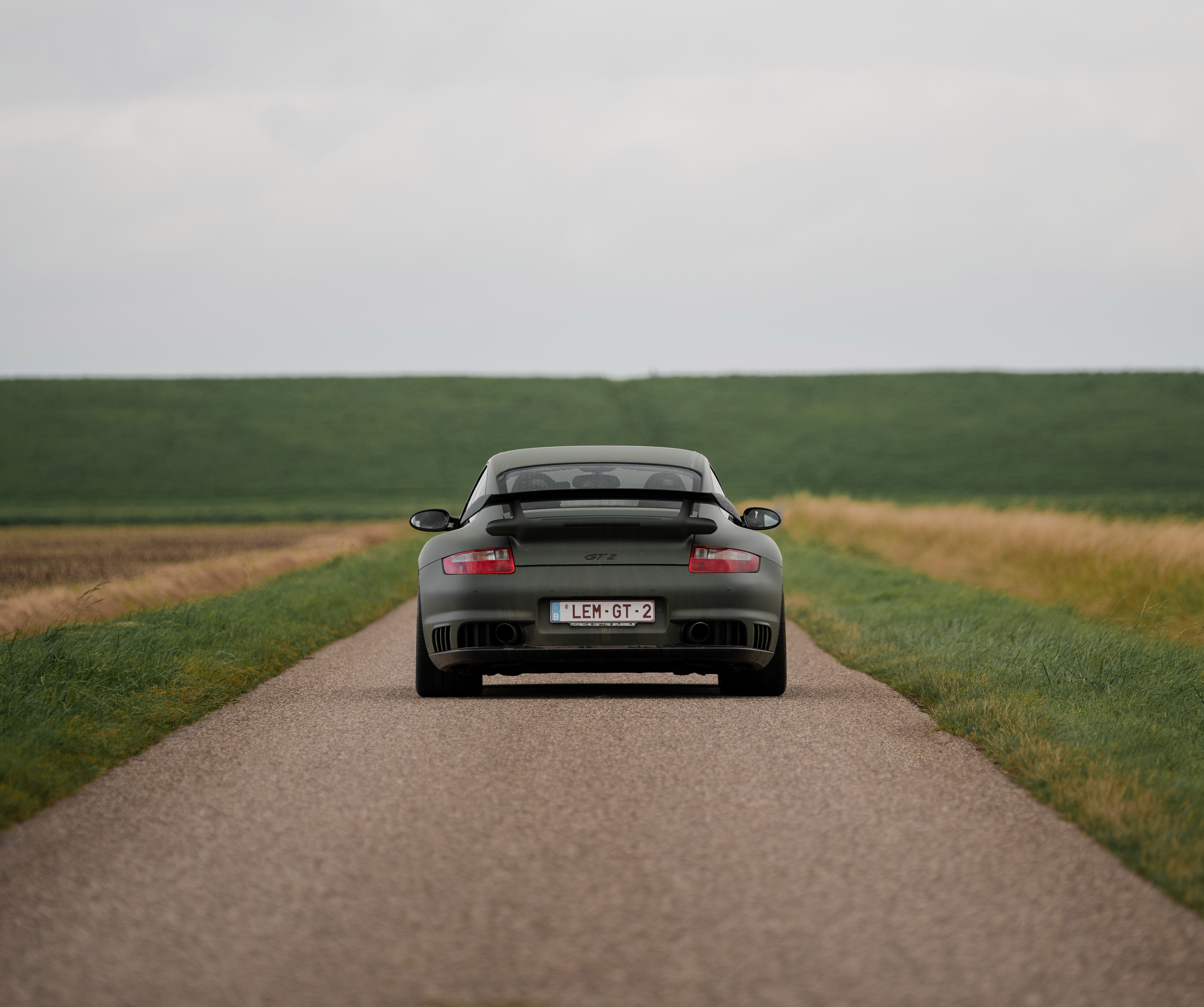 Rear view of 997 Porsche driving along country road